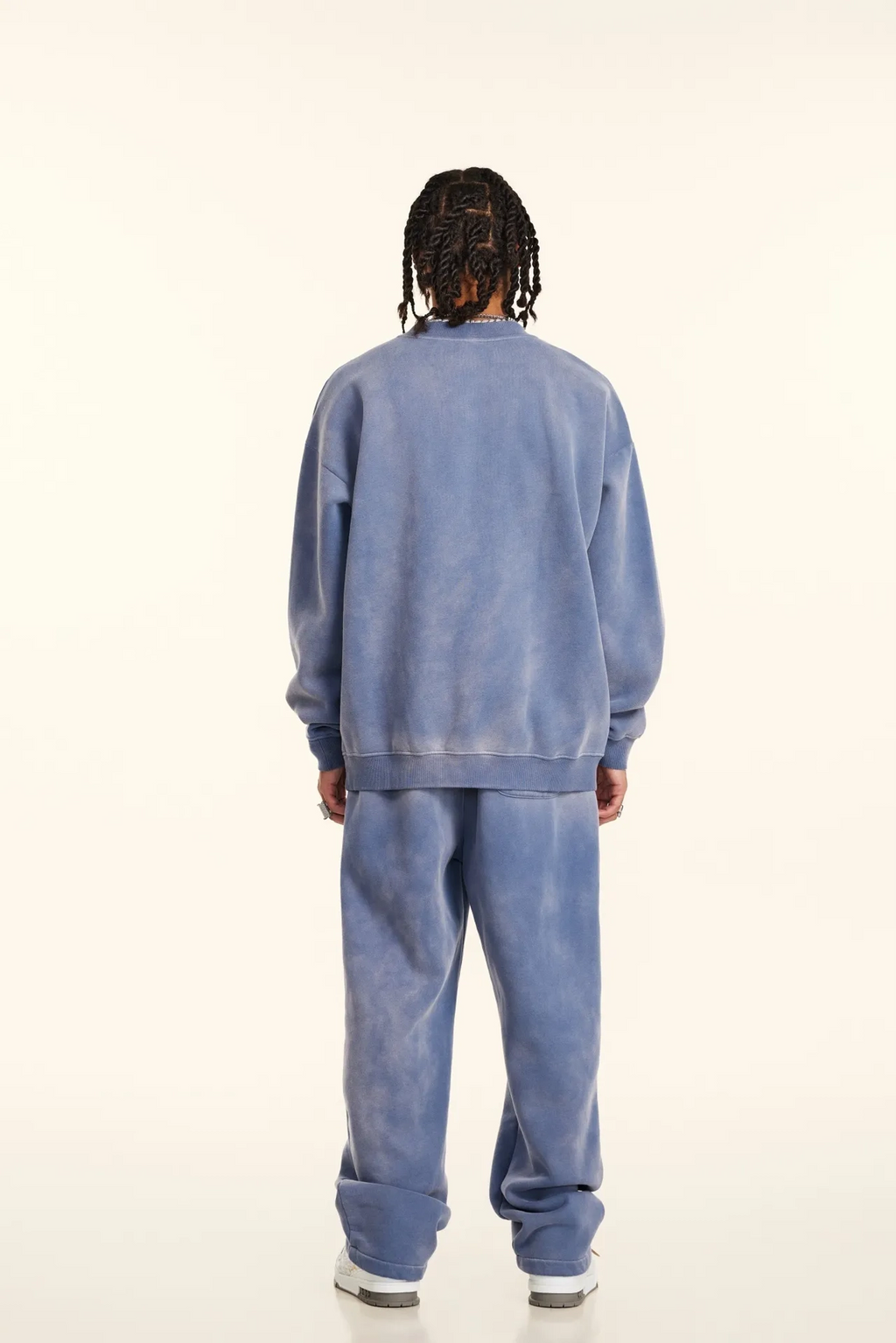 Person wearing a blue tracksuit from behind on a white background