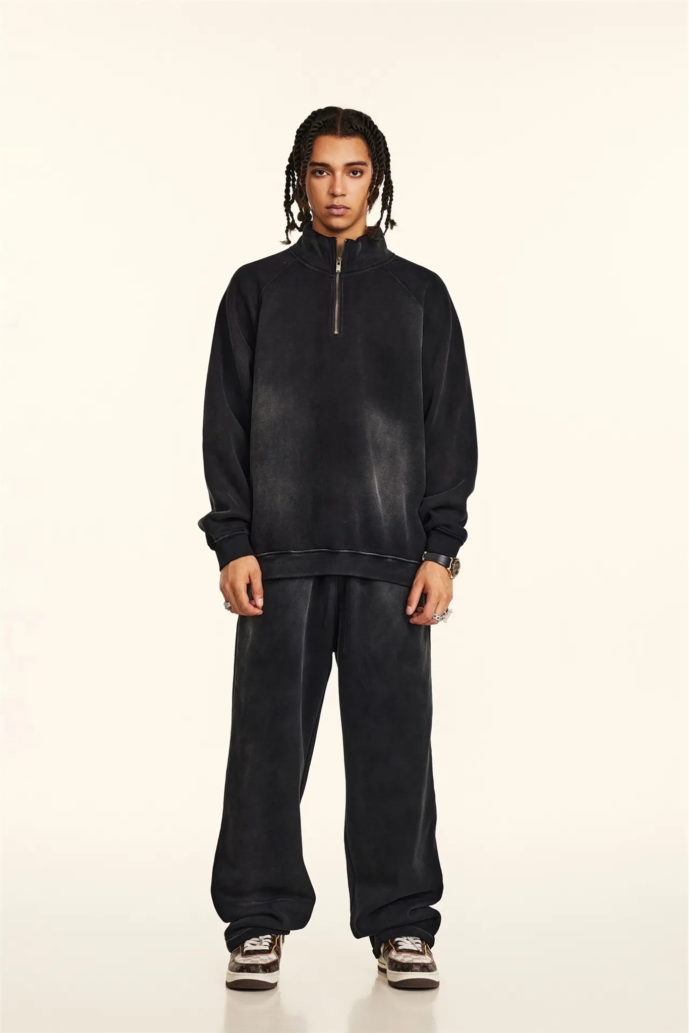 Person wearing a black tracksuit on a white background