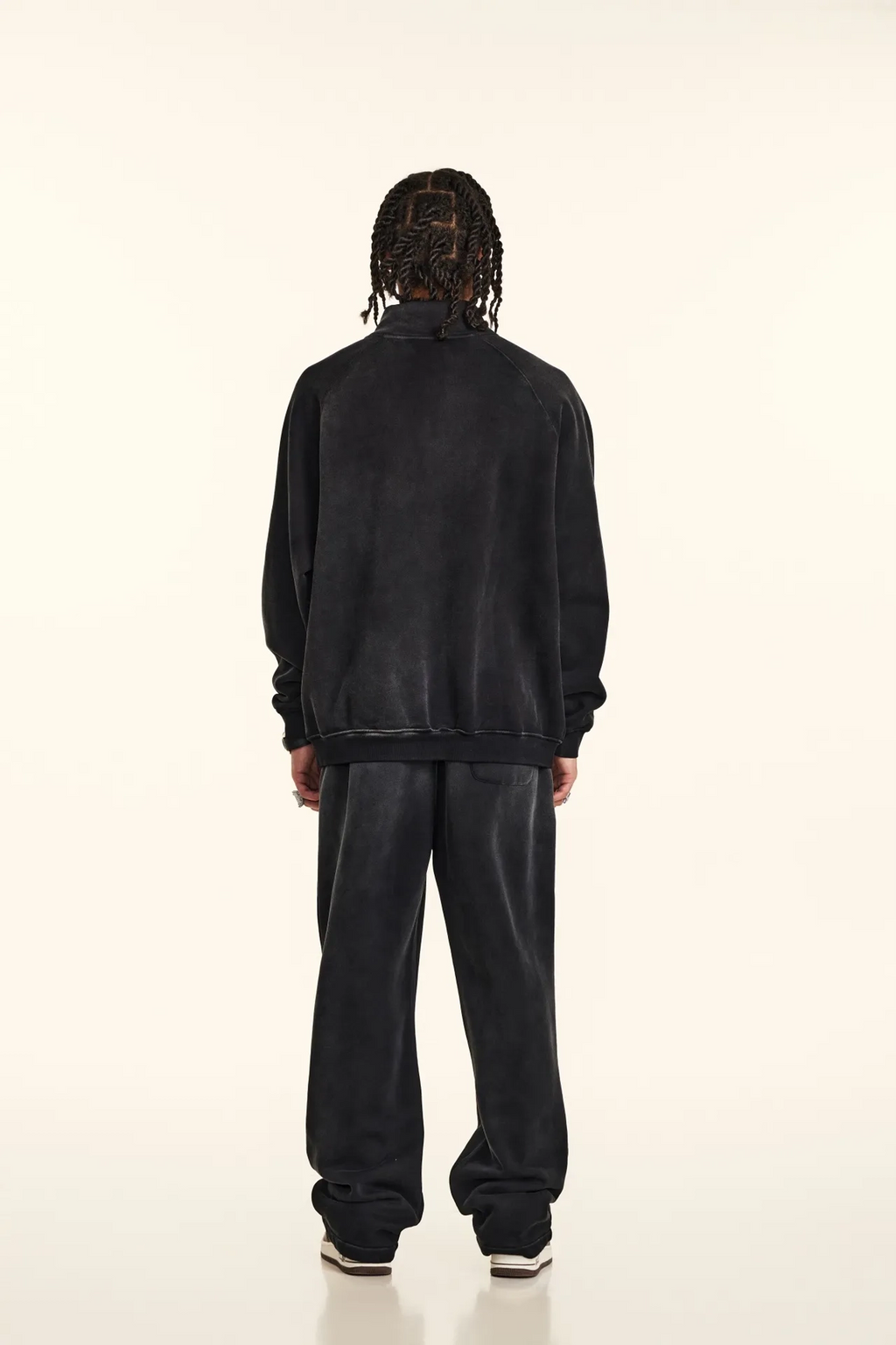 Person wearing a black tracksuit on a white background