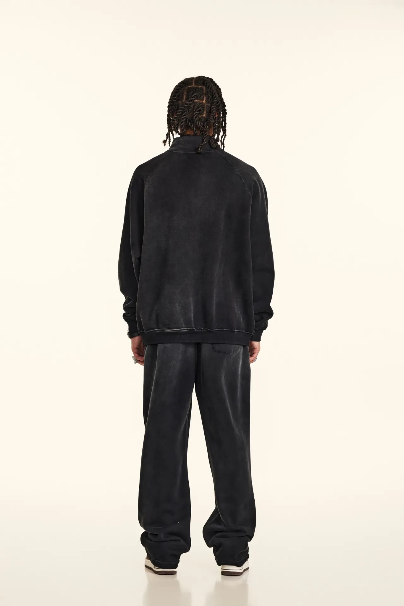 Person wearing a black tracksuit on a white background
