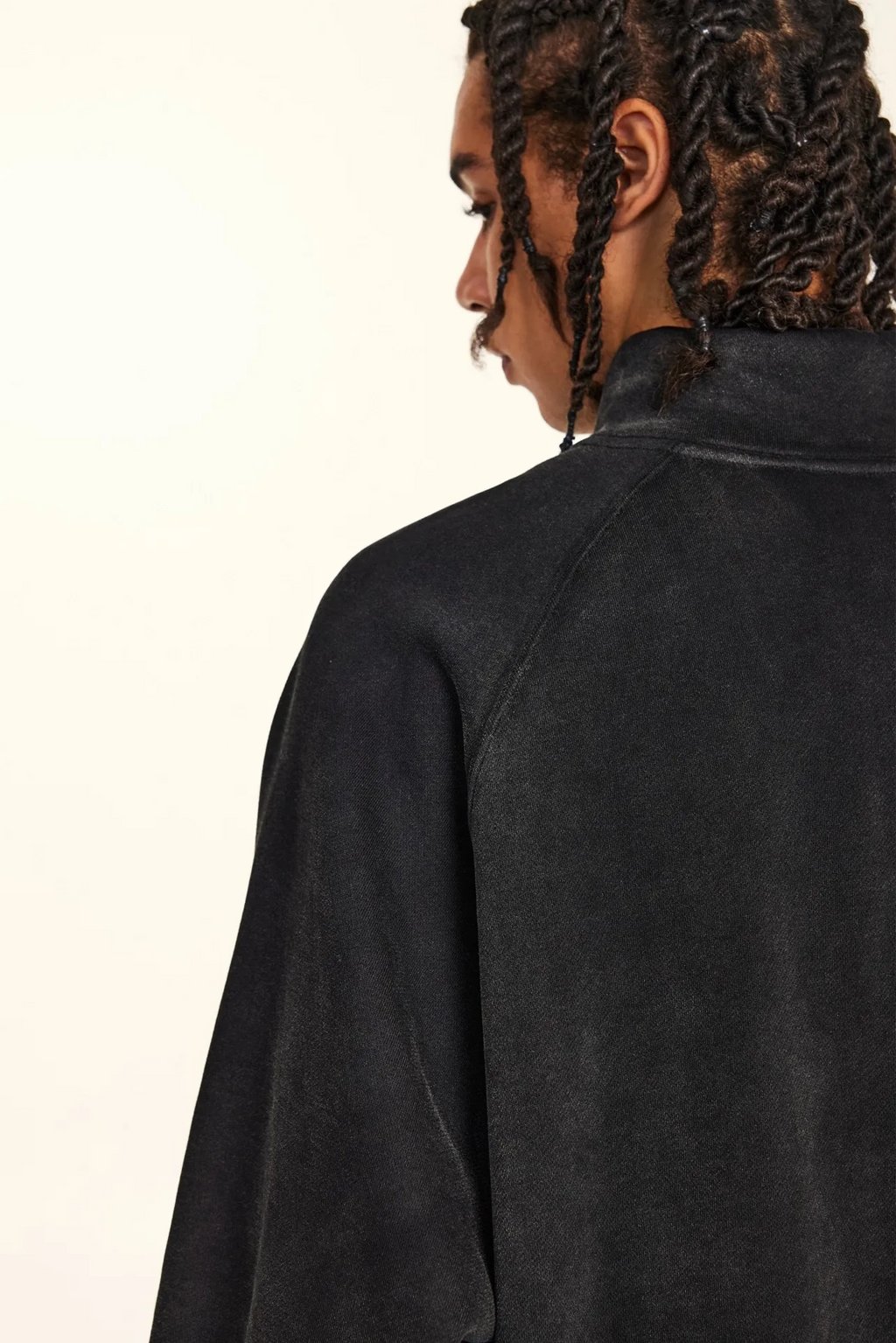 Person wearing a black jacket on a plain background