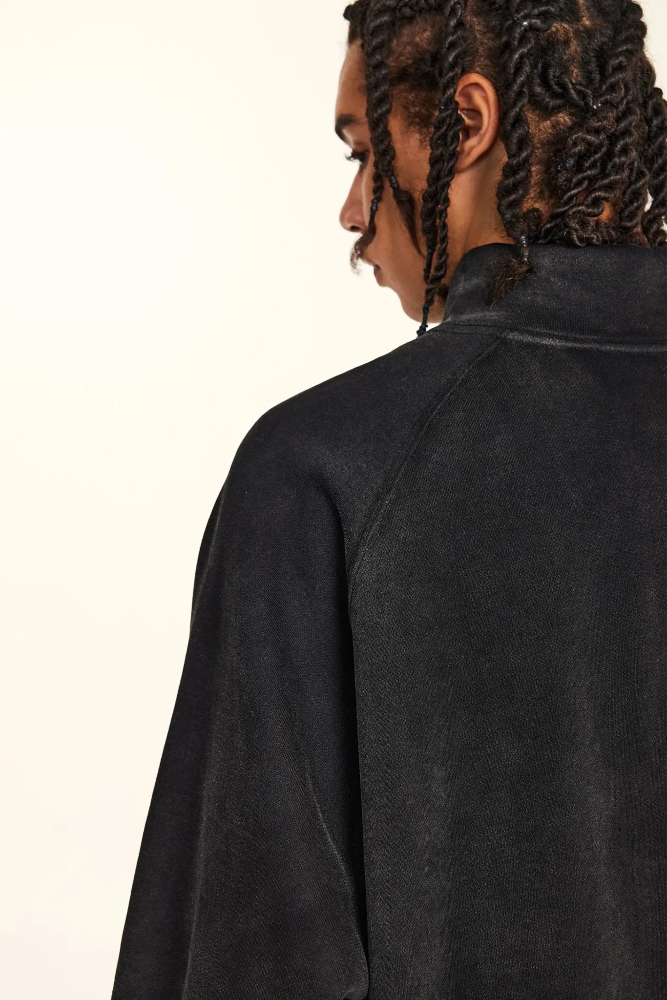 Person wearing a black jacket on a plain background