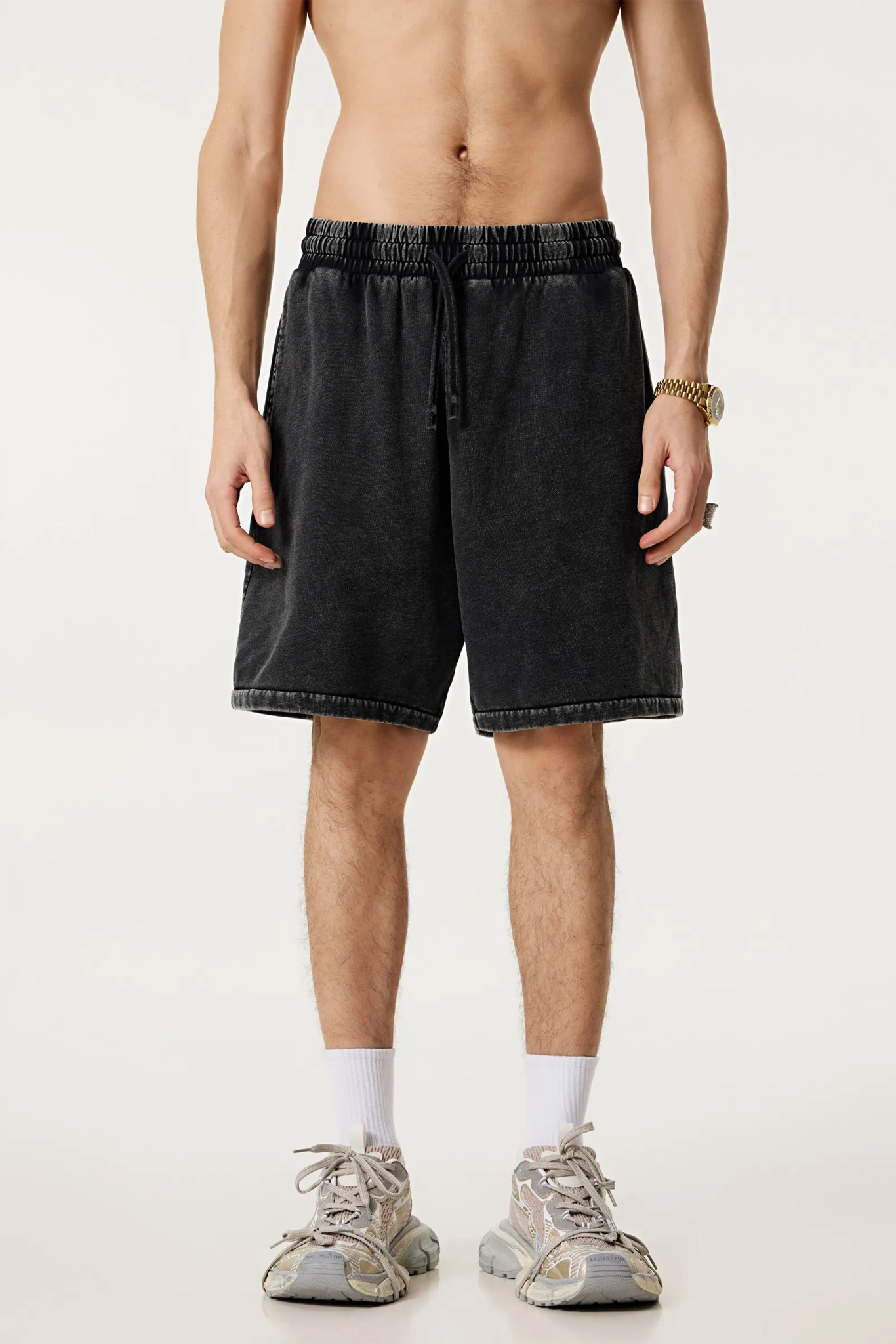 Person wearing black shorts on a white background