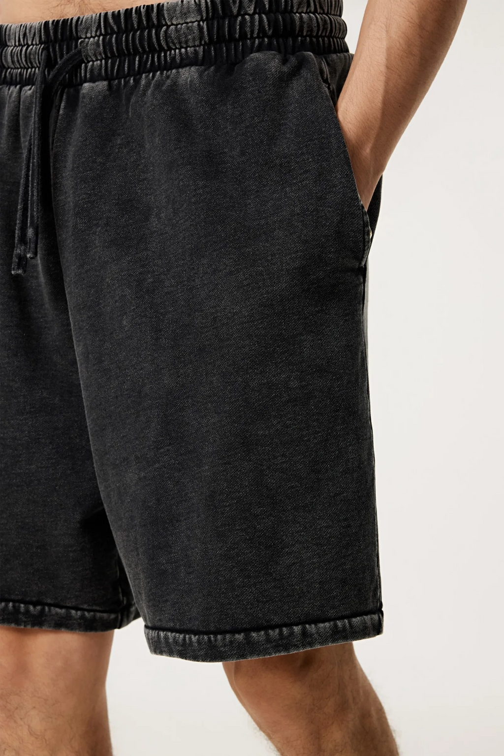 Black shorts worn by a person on a white background