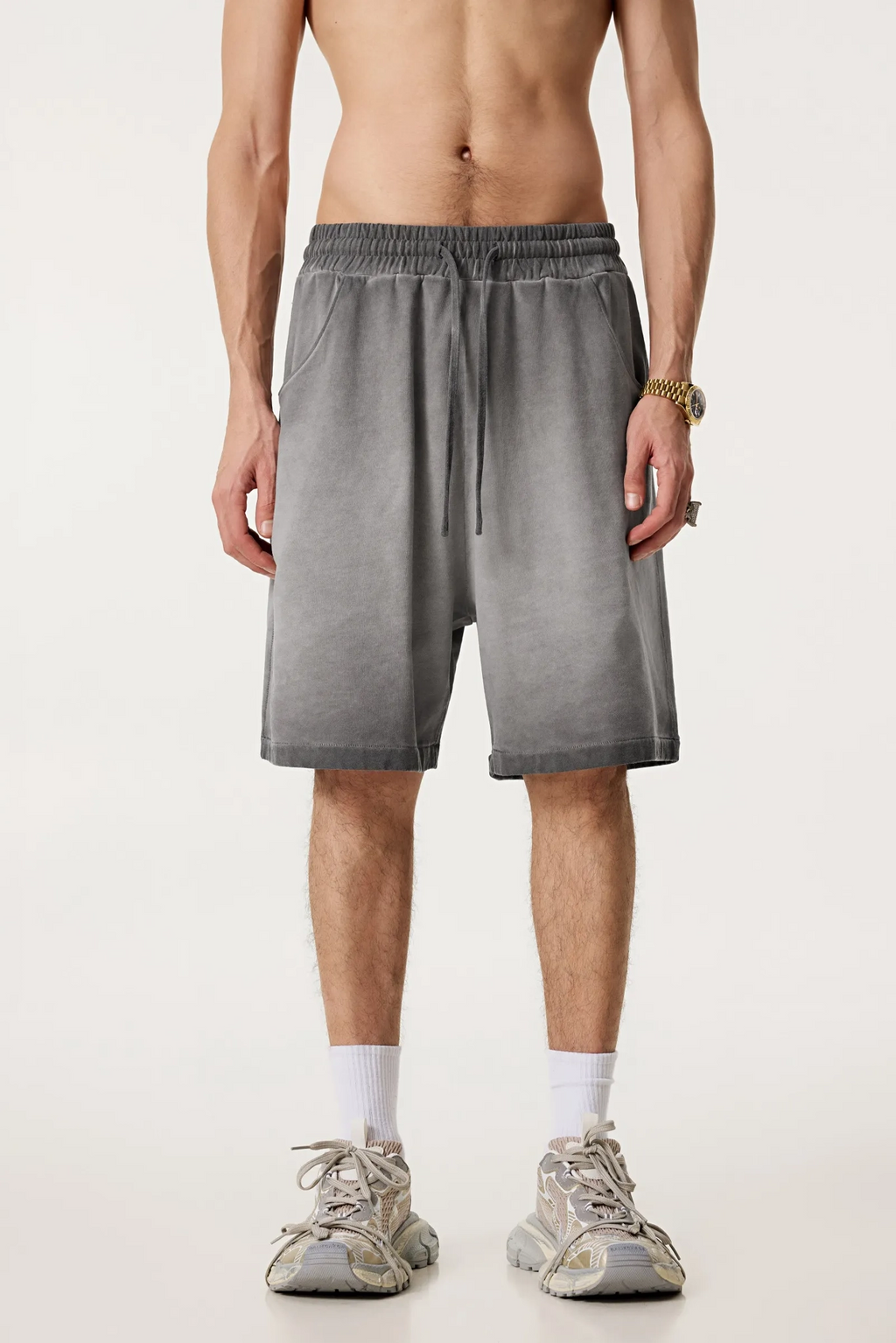 Person wearing gray shorts on a white background