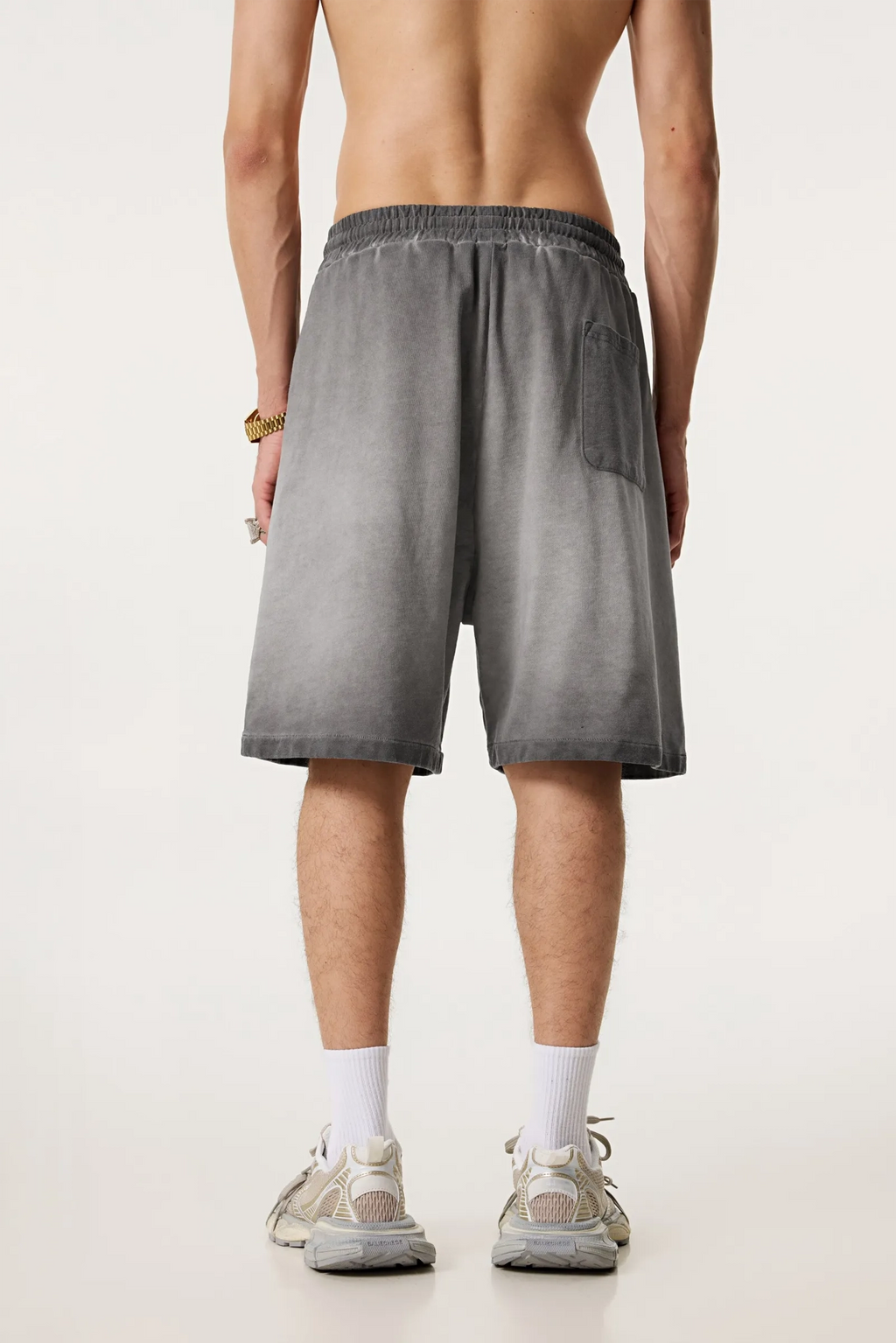 Person wearing gray shorts on a plain background