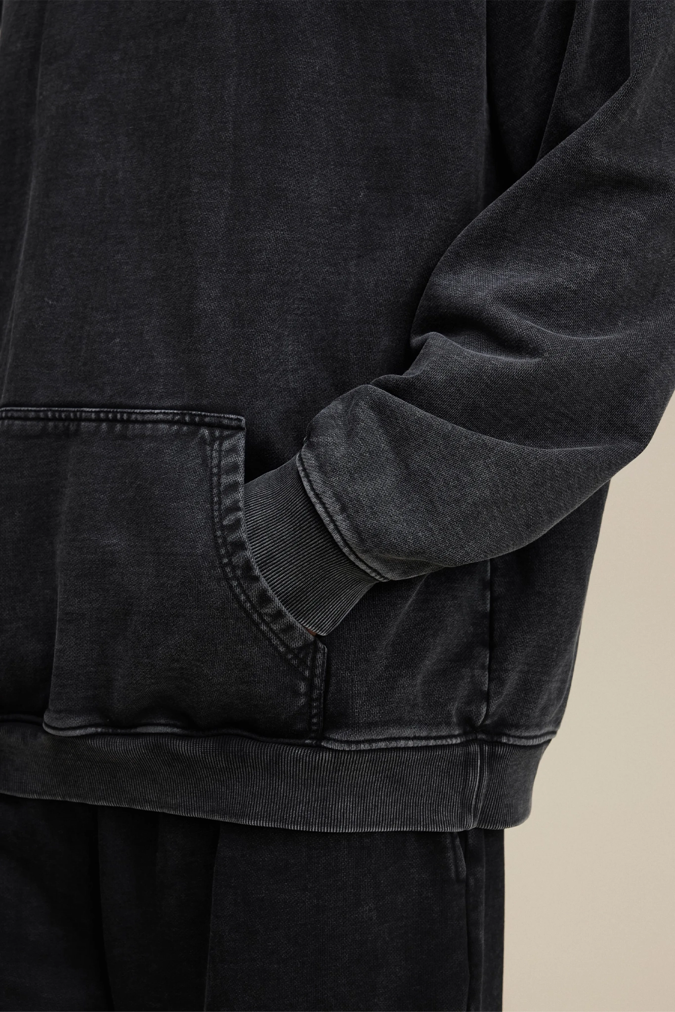 Close-up of a black jacket with a pocket on a beige background