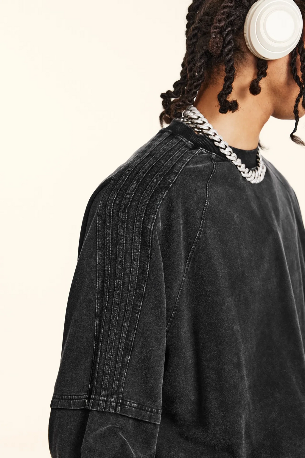 Person wearing a black denim jacket with a neutral background