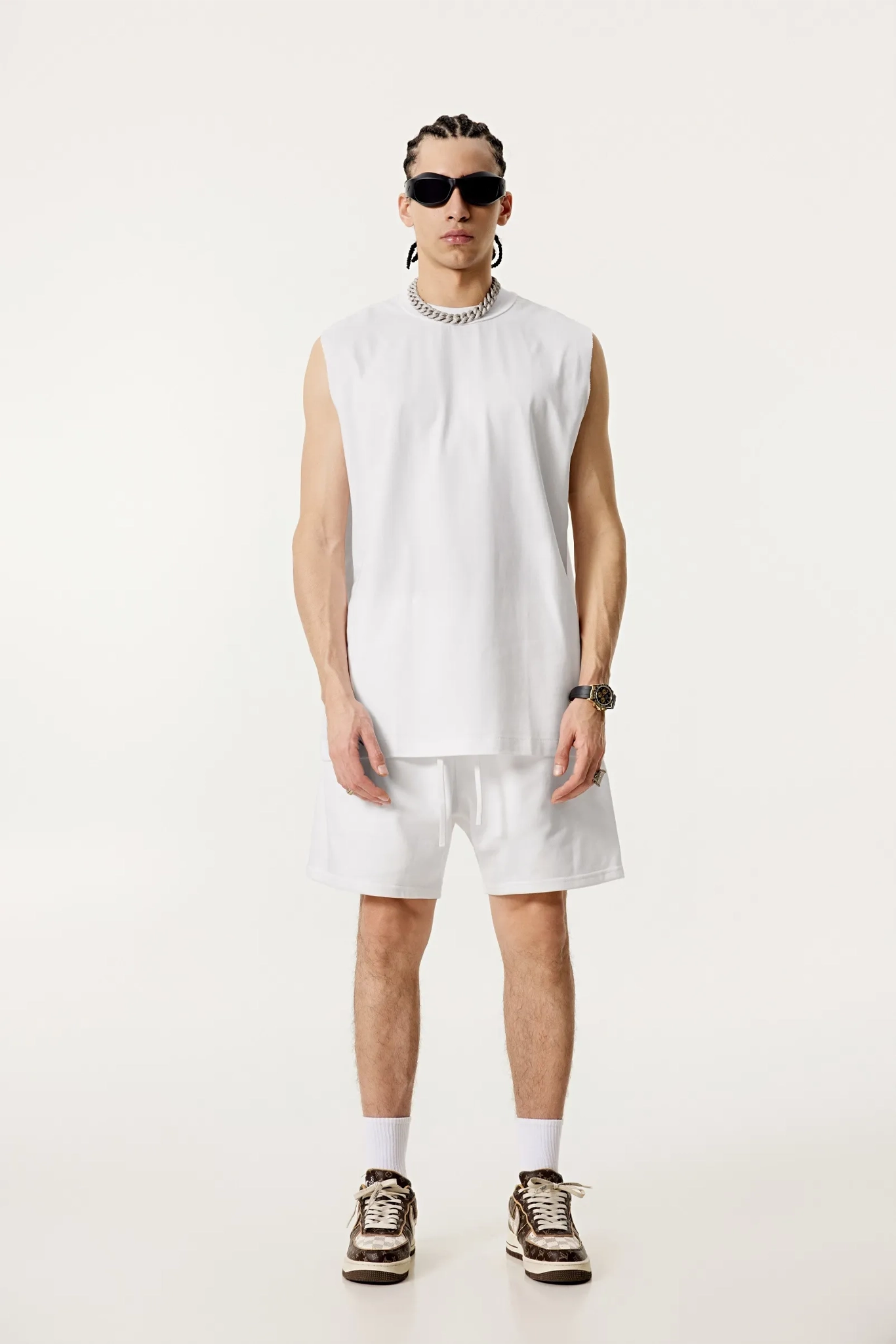 Person wearing a sleeveless white top and shorts on a white background