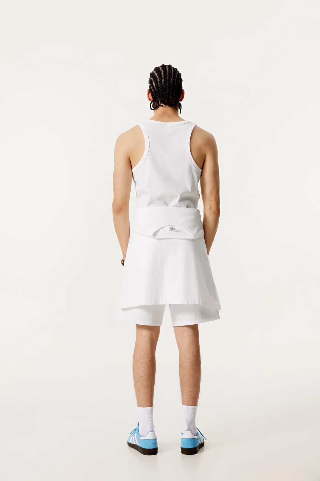 Person wearing a white dress with a bow detail on a plain background