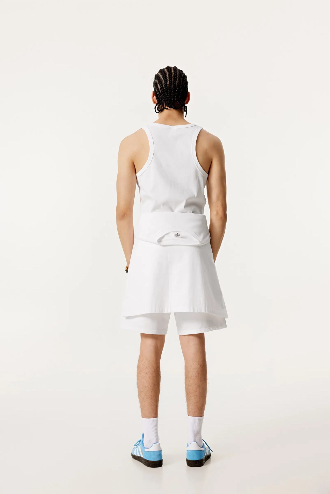 Person wearing a white dress with a bow detail on a plain background