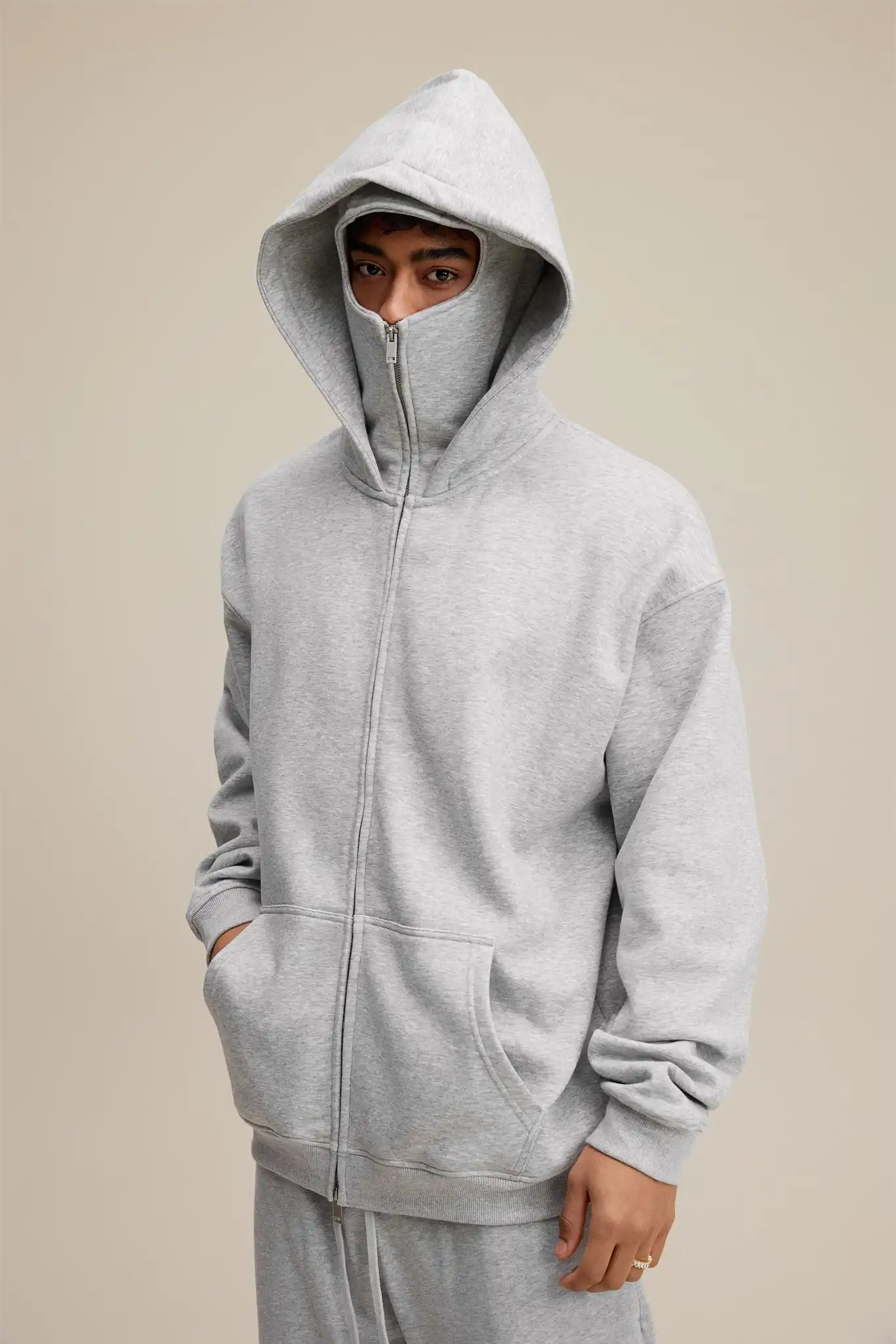 Person wearing a gray hoodie with a neutral background