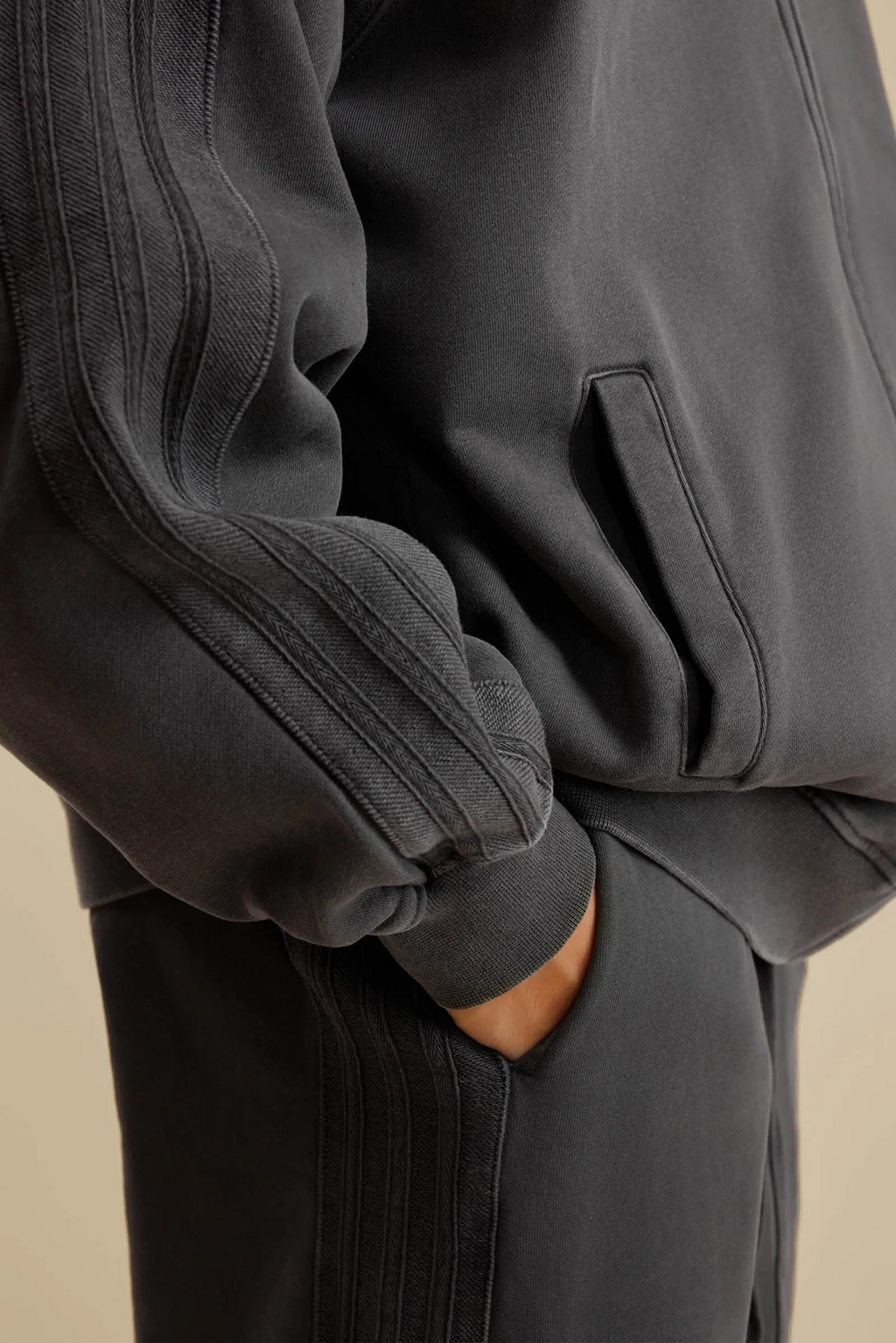 Dark gray hoodie and pants on a beige background