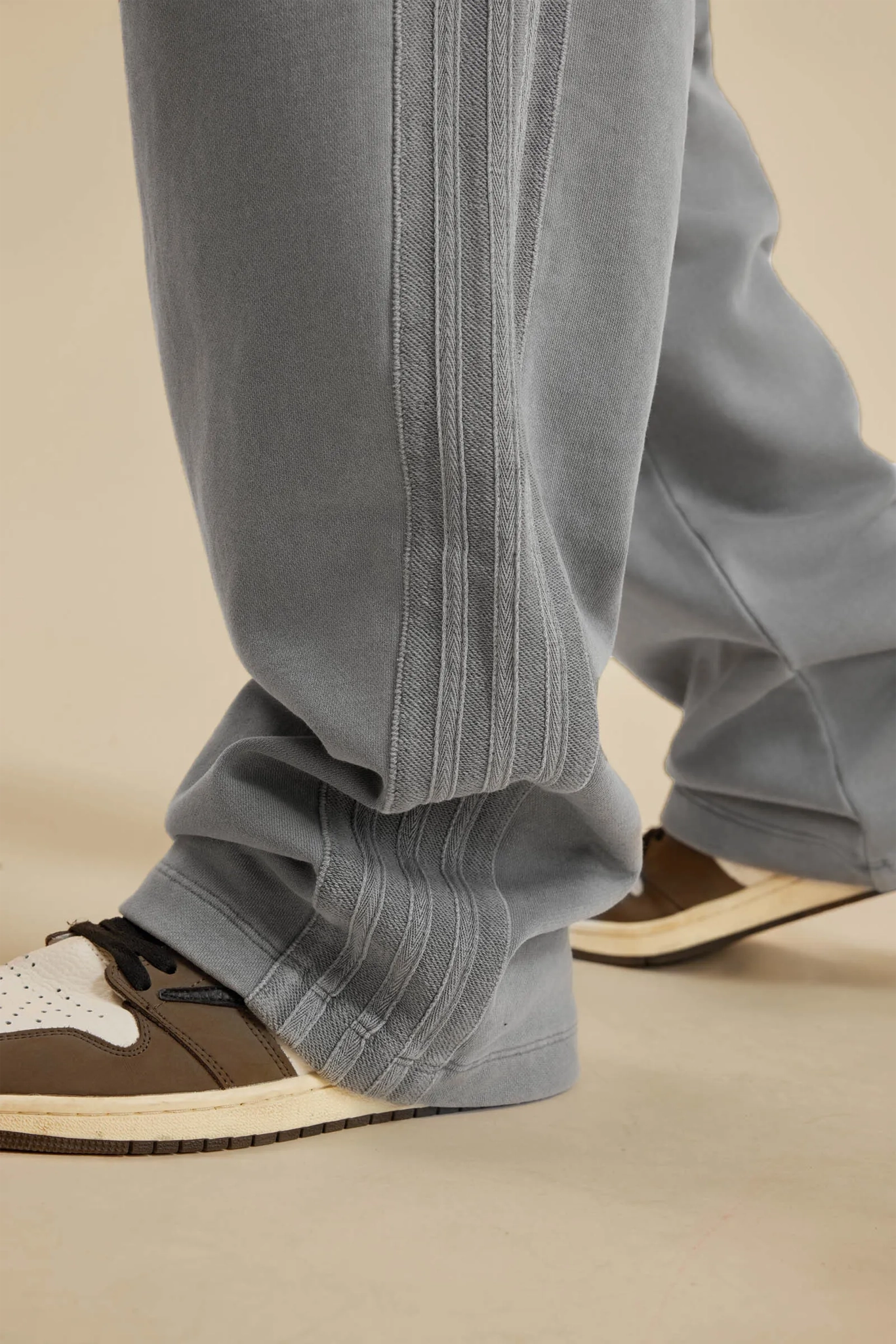 Gray pants worn with brown shoes on a beige background