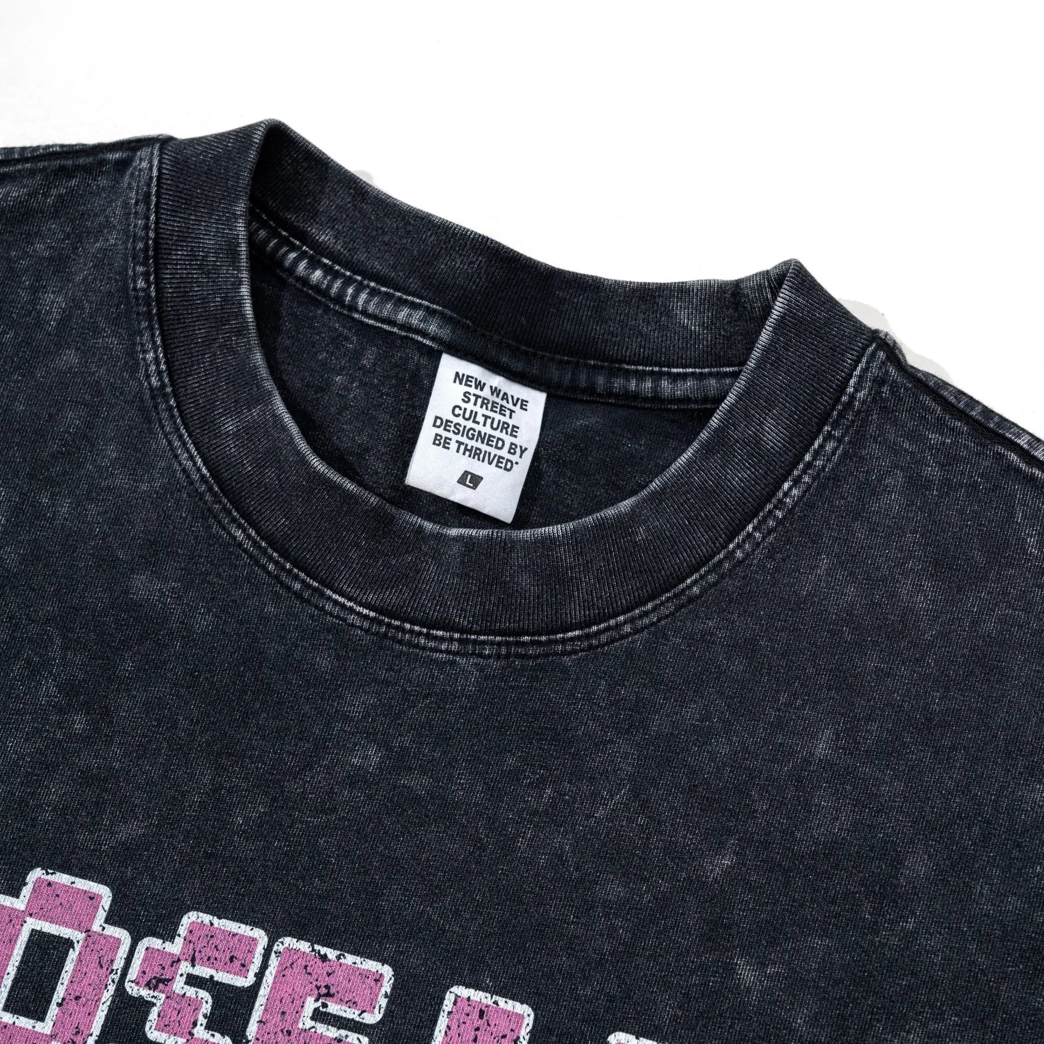 Black t-shirt with pink text and a brand label on a white background