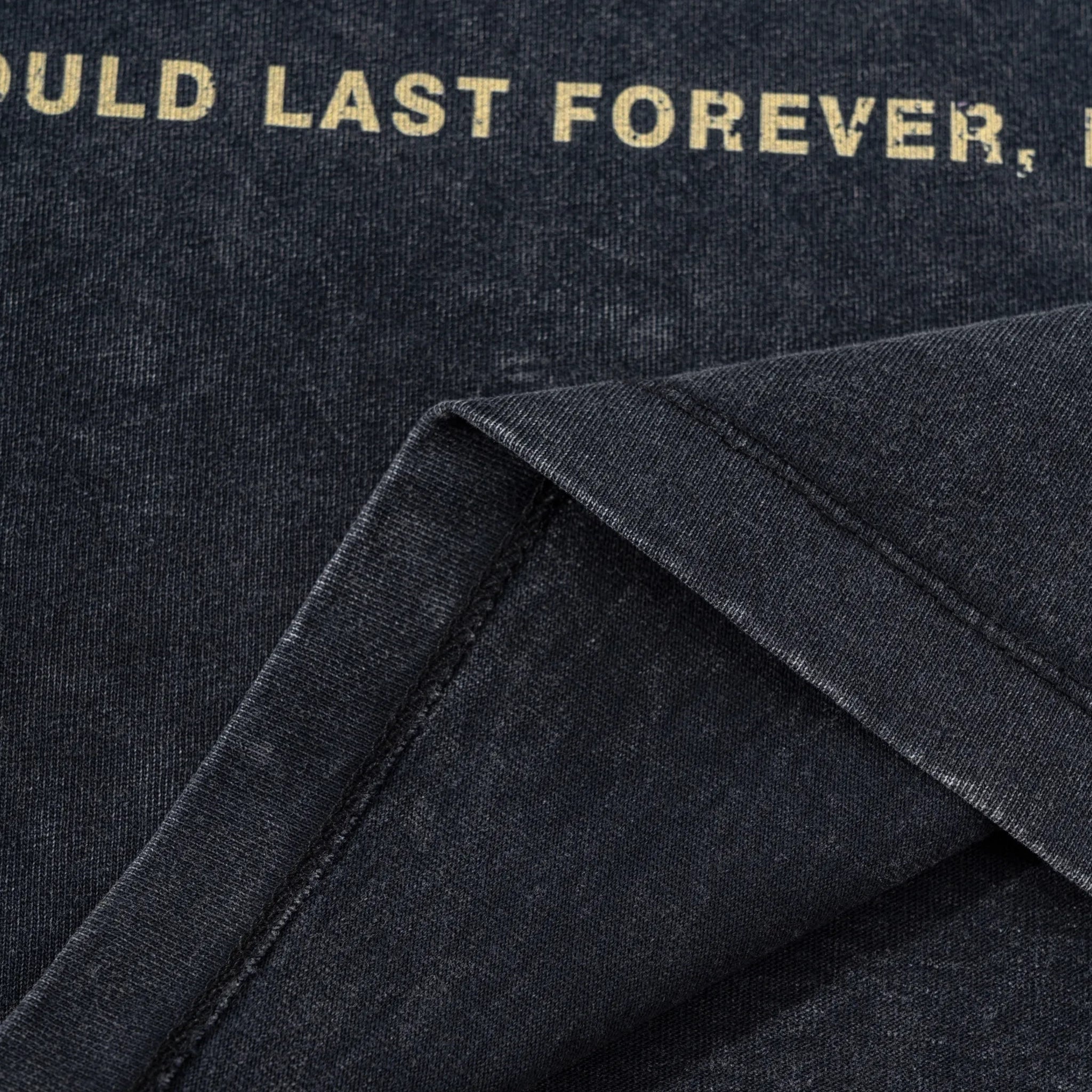 Close-up of a dark fabric with gold text on a black background