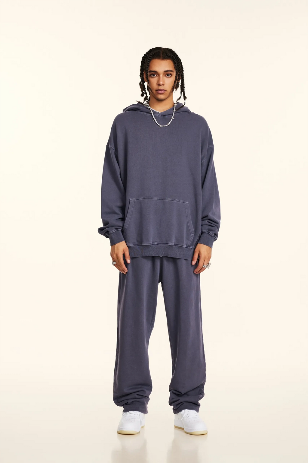 Person wearing a gray tracksuit on a white background