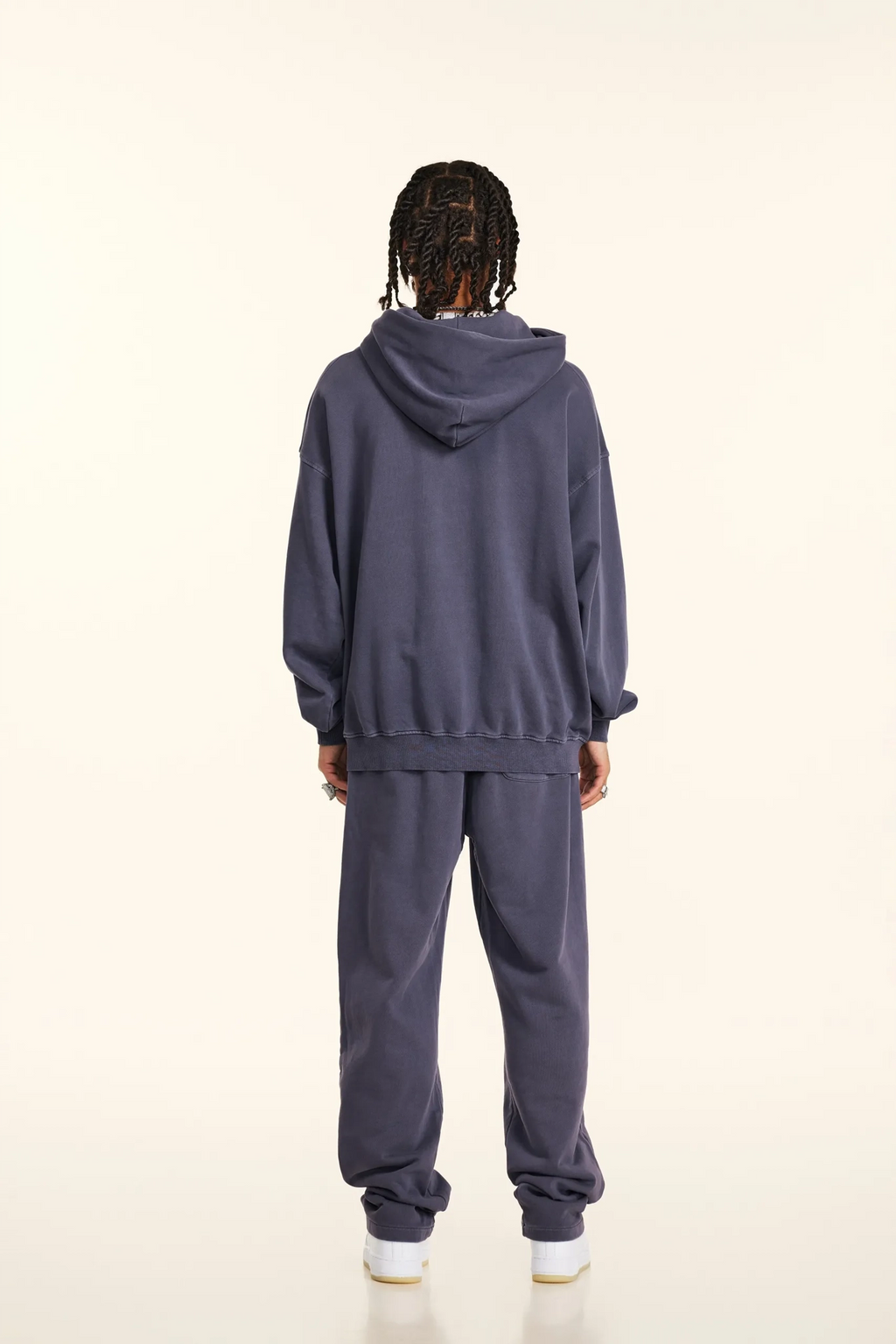 Person wearing a gray tracksuit on a white background