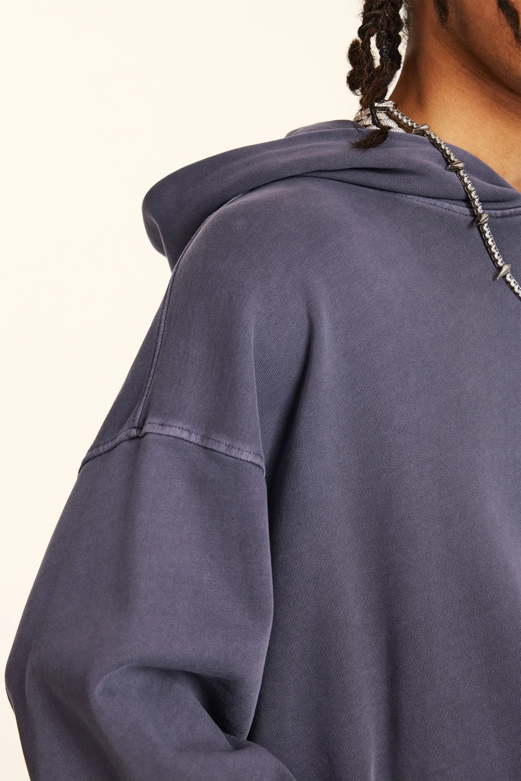 Close-up of a person wearing a blue hoodie with a neutral background