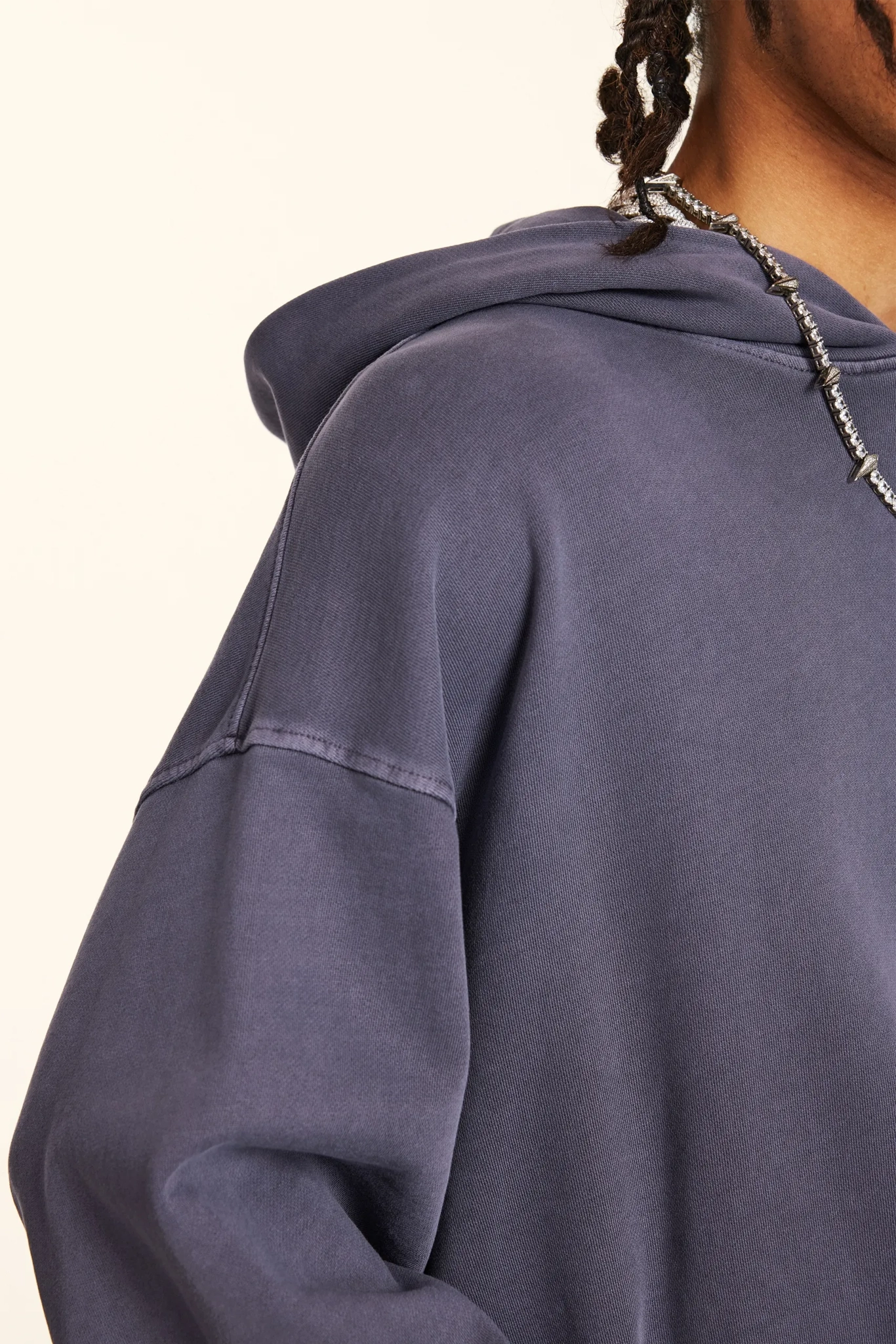 Close-up of a person wearing a blue hoodie with a neutral background