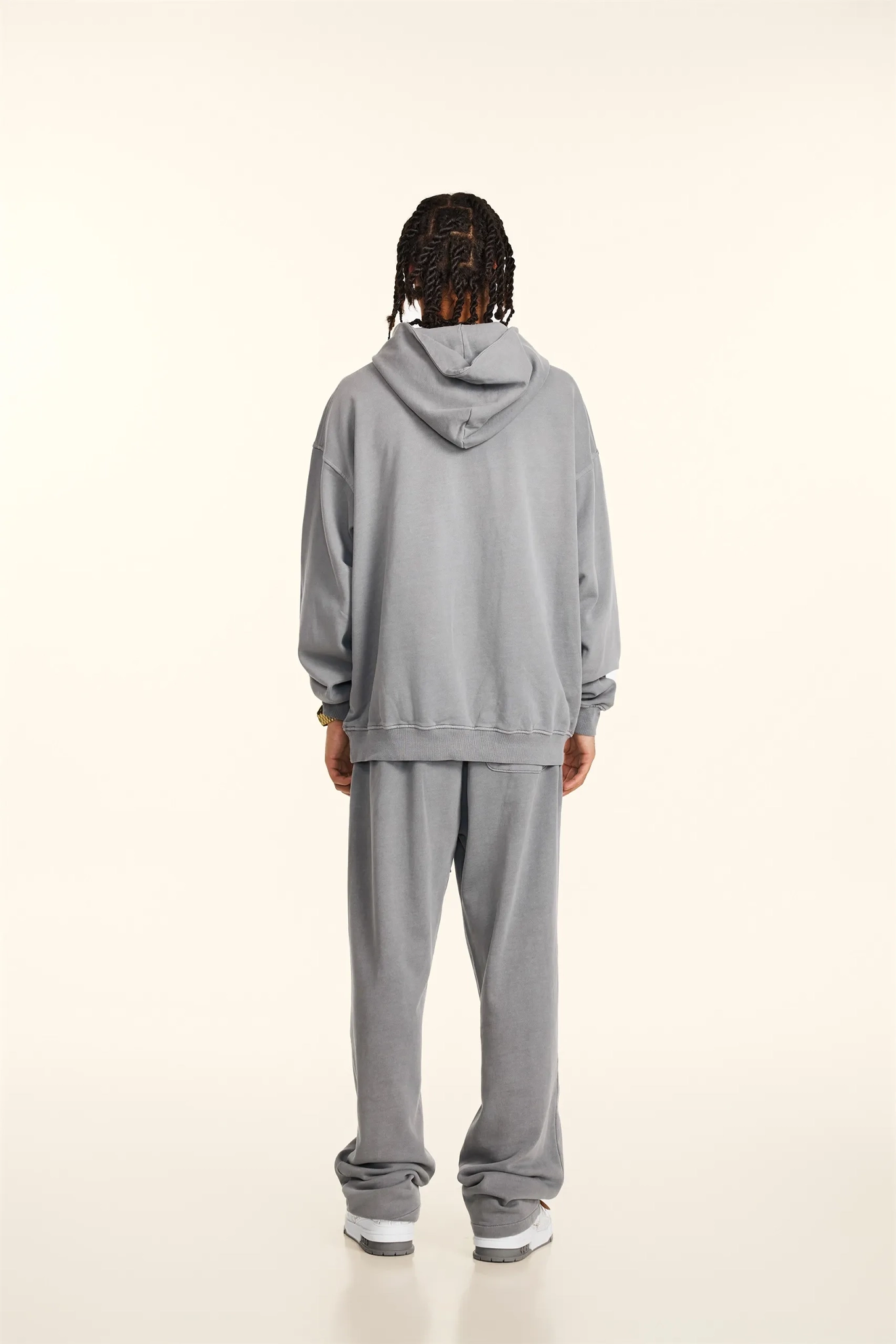 Person wearing a gray tracksuit on a white background