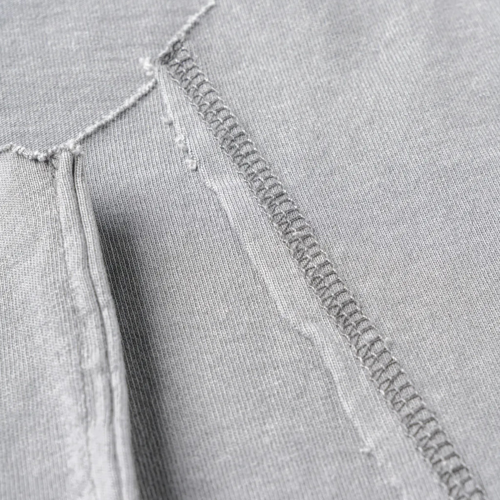 Close-up of a gray fabric with a zipper and stitching detail
