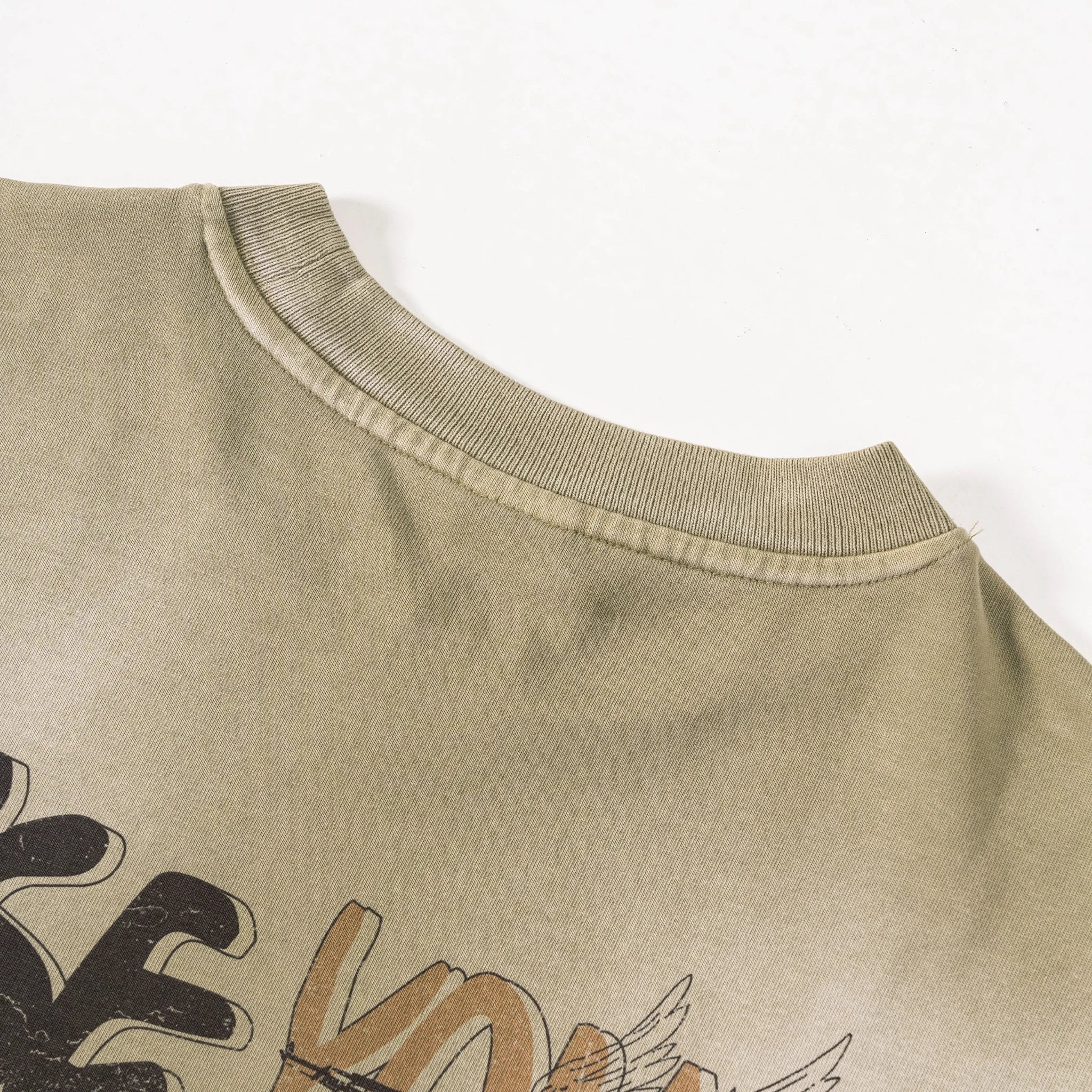 Close-up of a beige sweatshirt with text and graphics on a white background