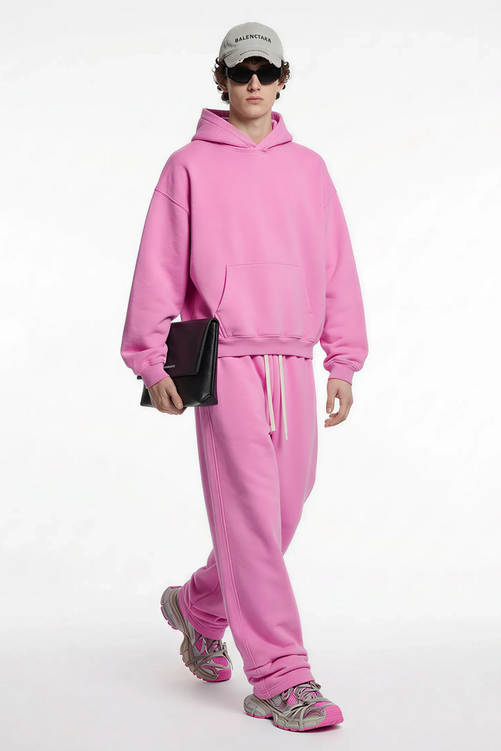 Person wearing a pink tracksuit with a white background