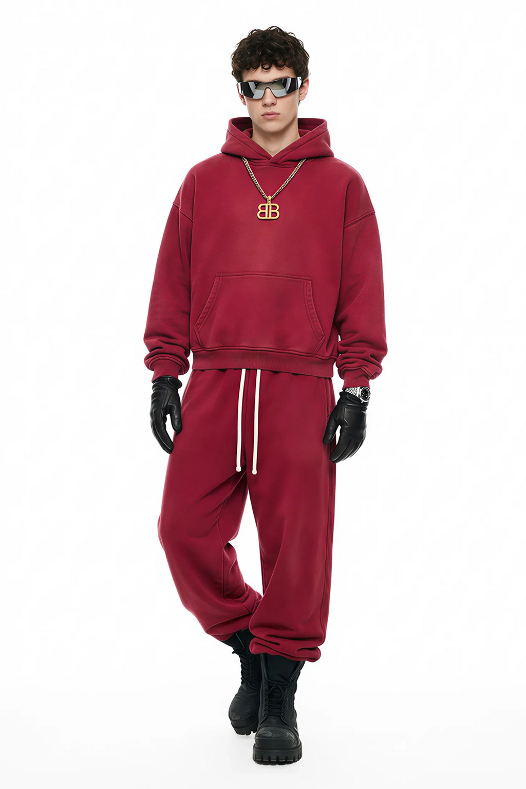 Person wearing a red tracksuit with a gold necklace on a white background