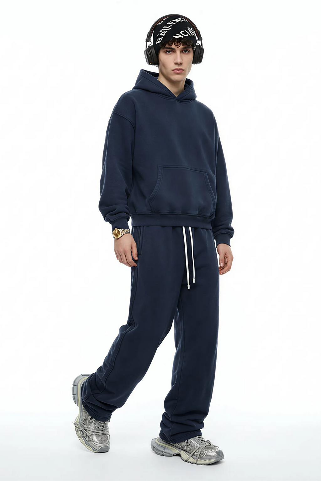 Person wearing a navy tracksuit with a white background