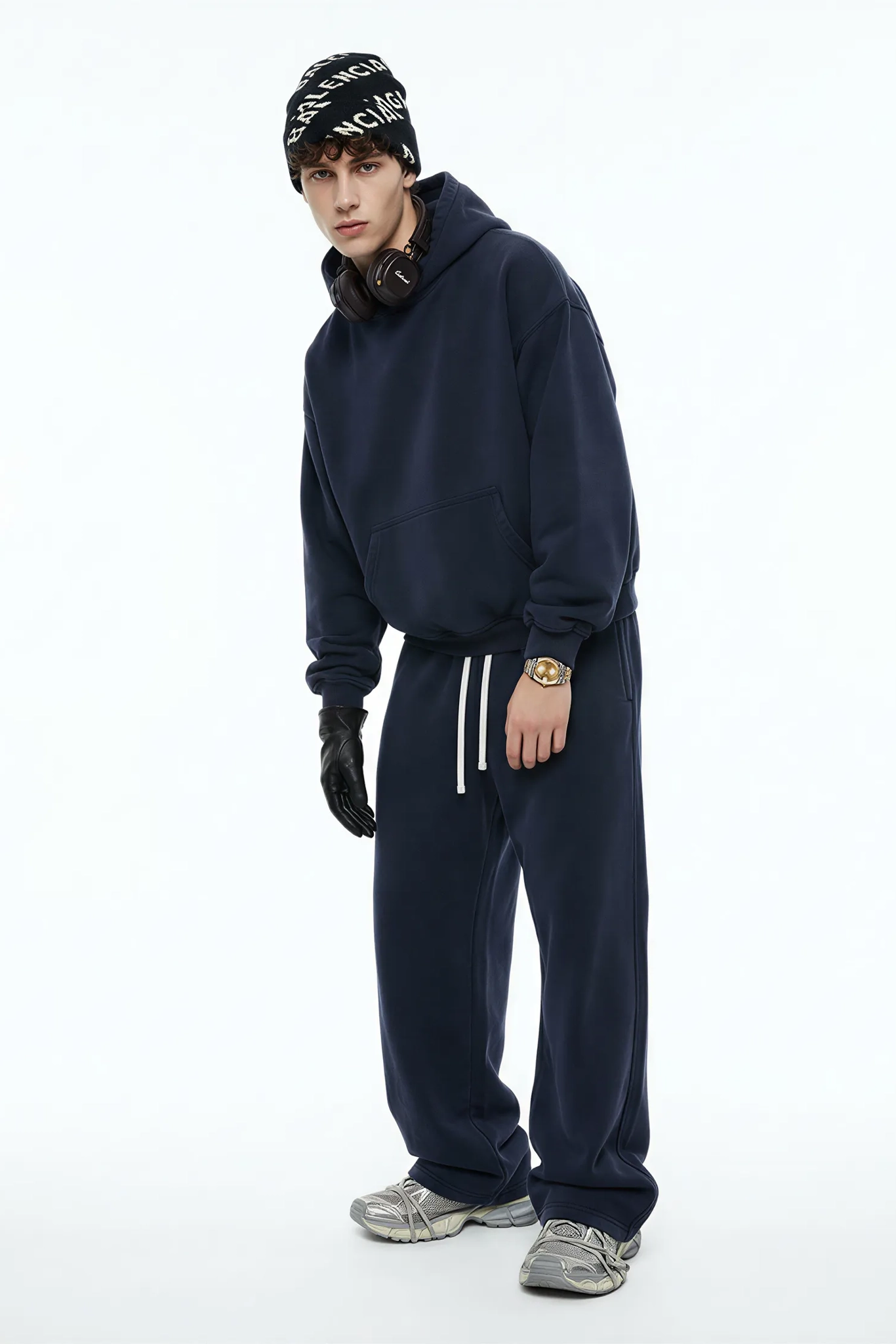 Person wearing a navy tracksuit with a beanie on a white background