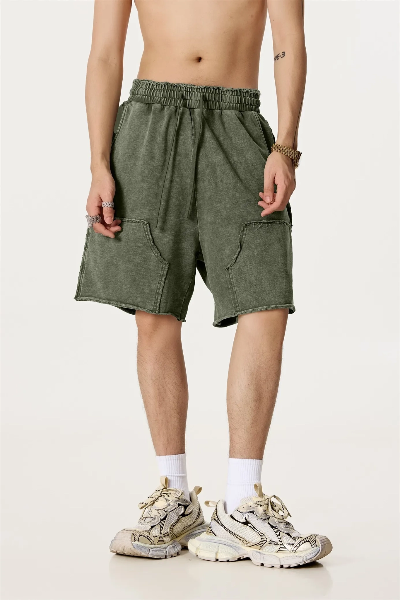 Person wearing green shorts on a plain background