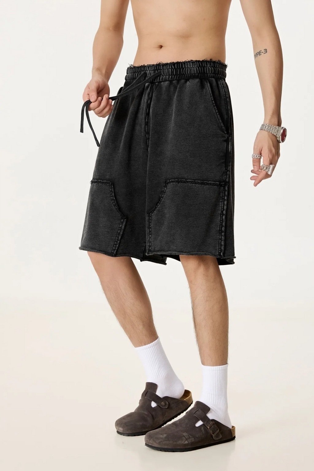 Person wearing black shorts on a white background