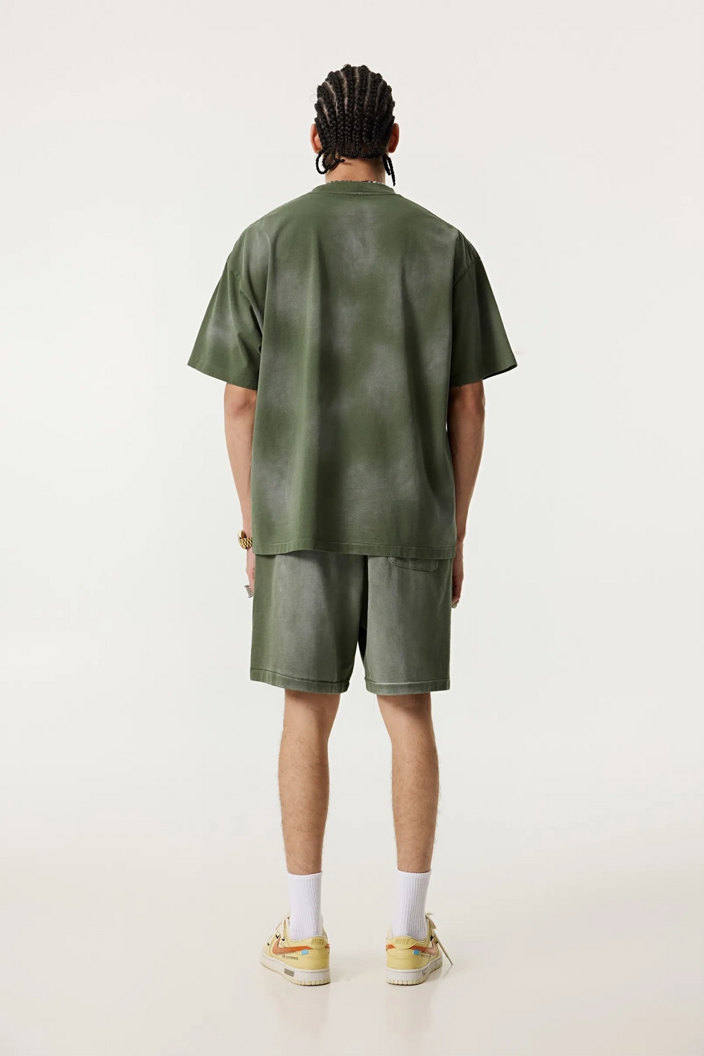 Person wearing a green outfit on a white background