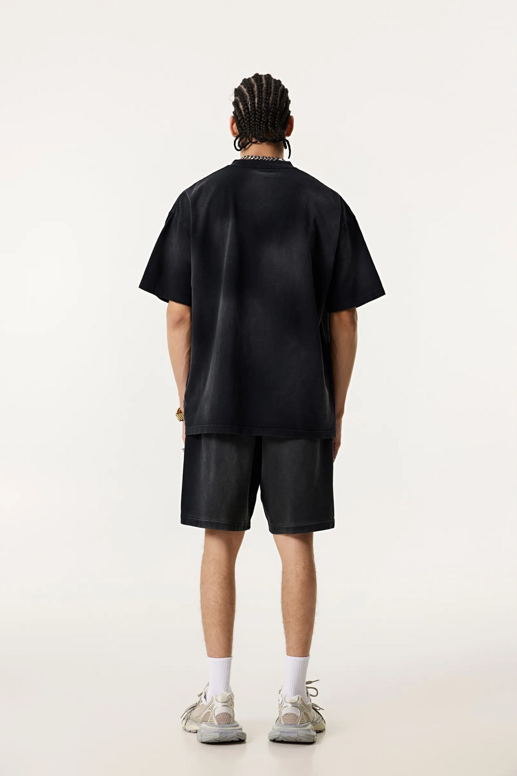 Person wearing a black t-shirt and shorts on a white background