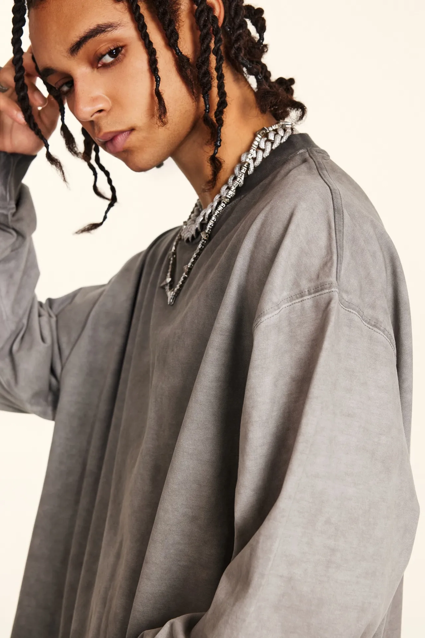 Person wearing a gray sweatshirt with a neutral background