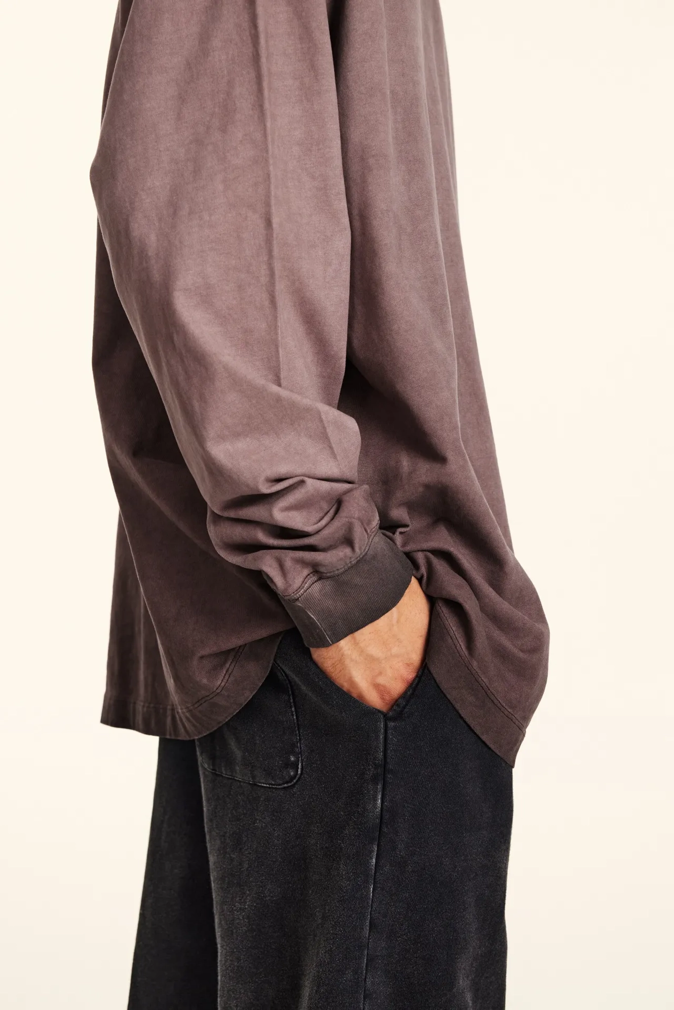 Brown long-sleeve shirt and black pants on a beige background