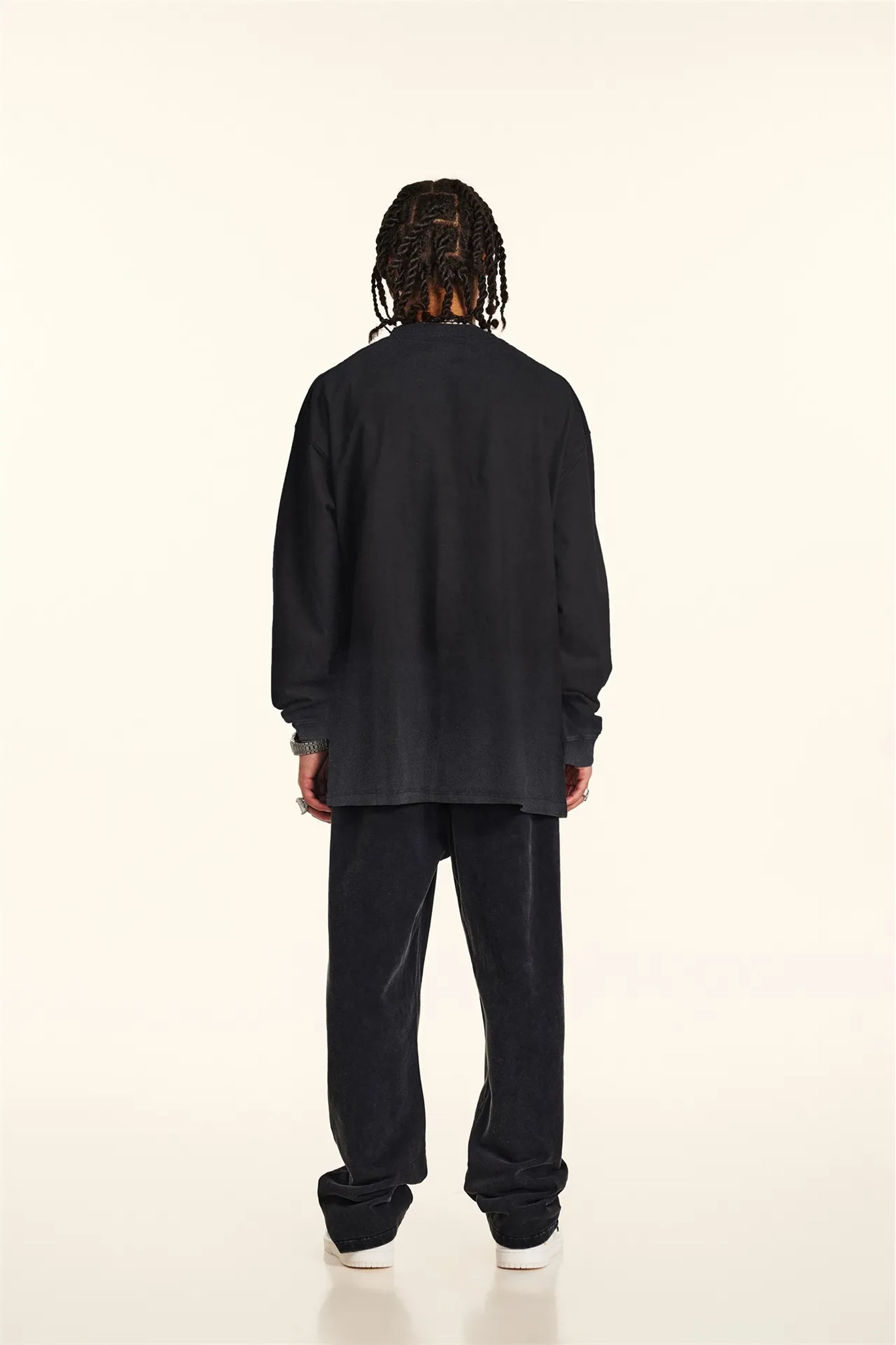 Person wearing a black outfit on a white background