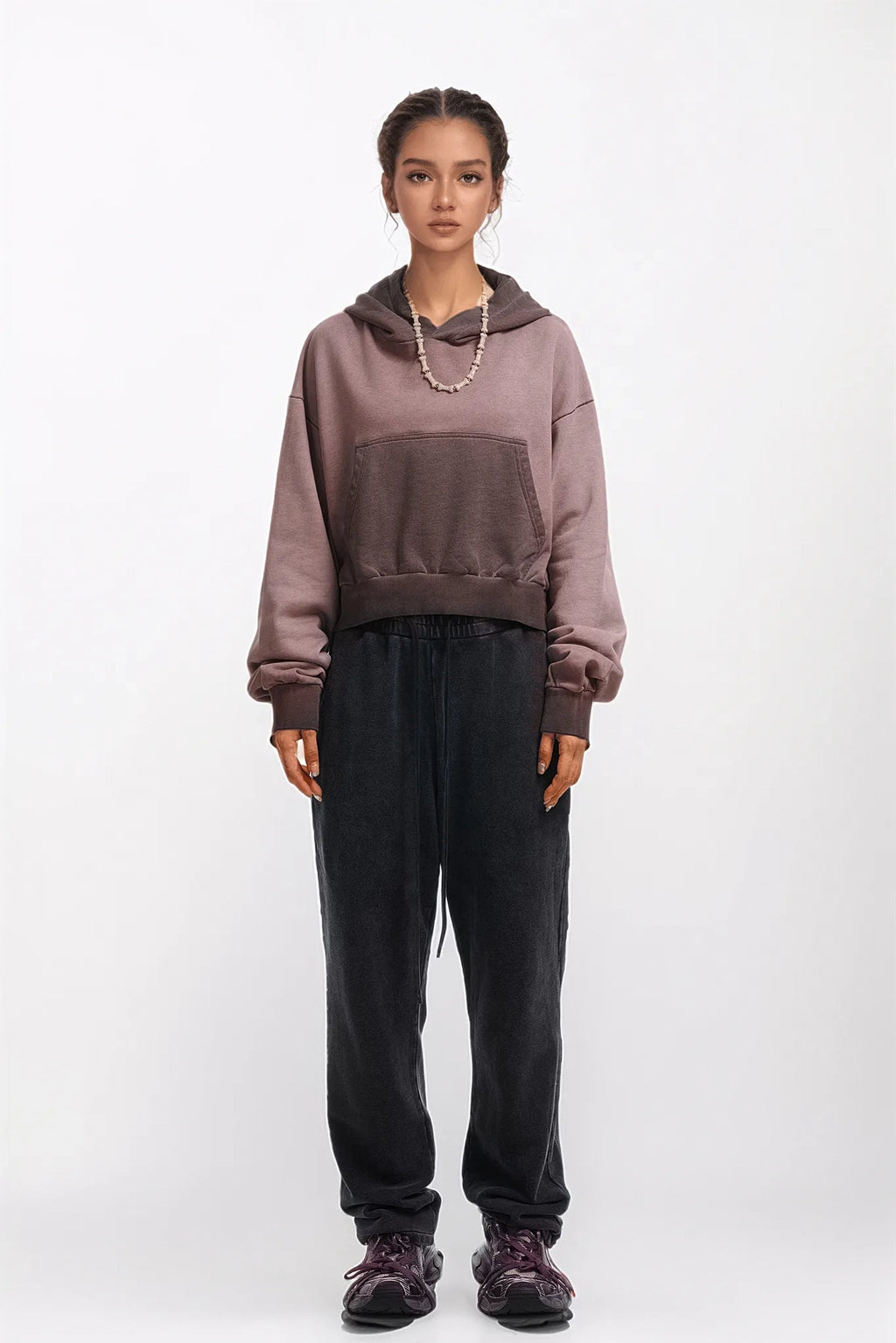 Person wearing a two-tone hoodie and black pants on a white background