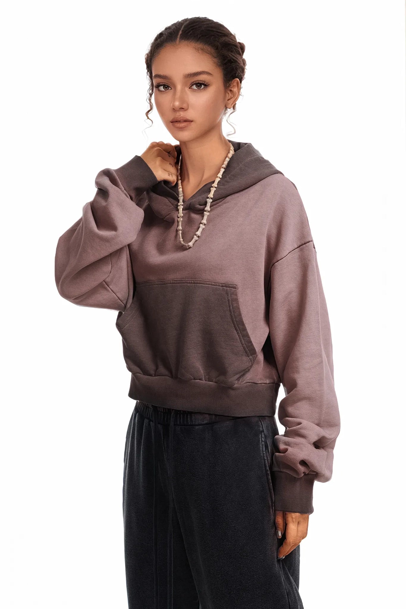 Woman wearing a two-tone hoodie with a gradient from light to dark brown on a white background