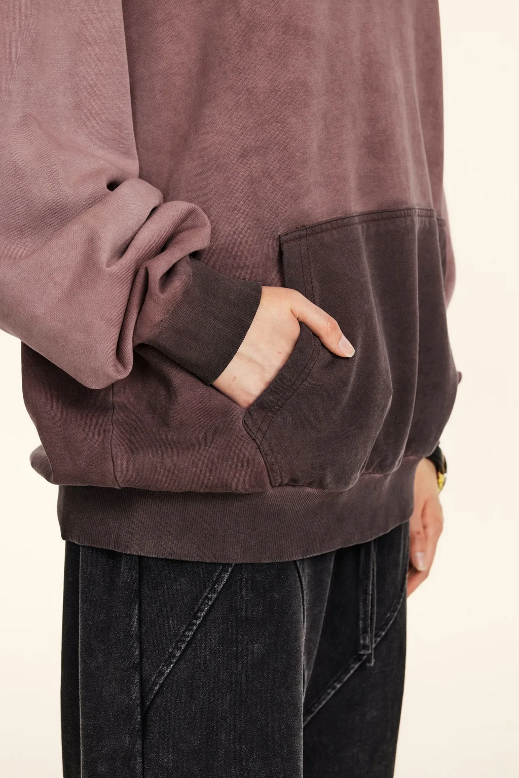 Close-up of a person wearing a brown suede jacket with a neutral background