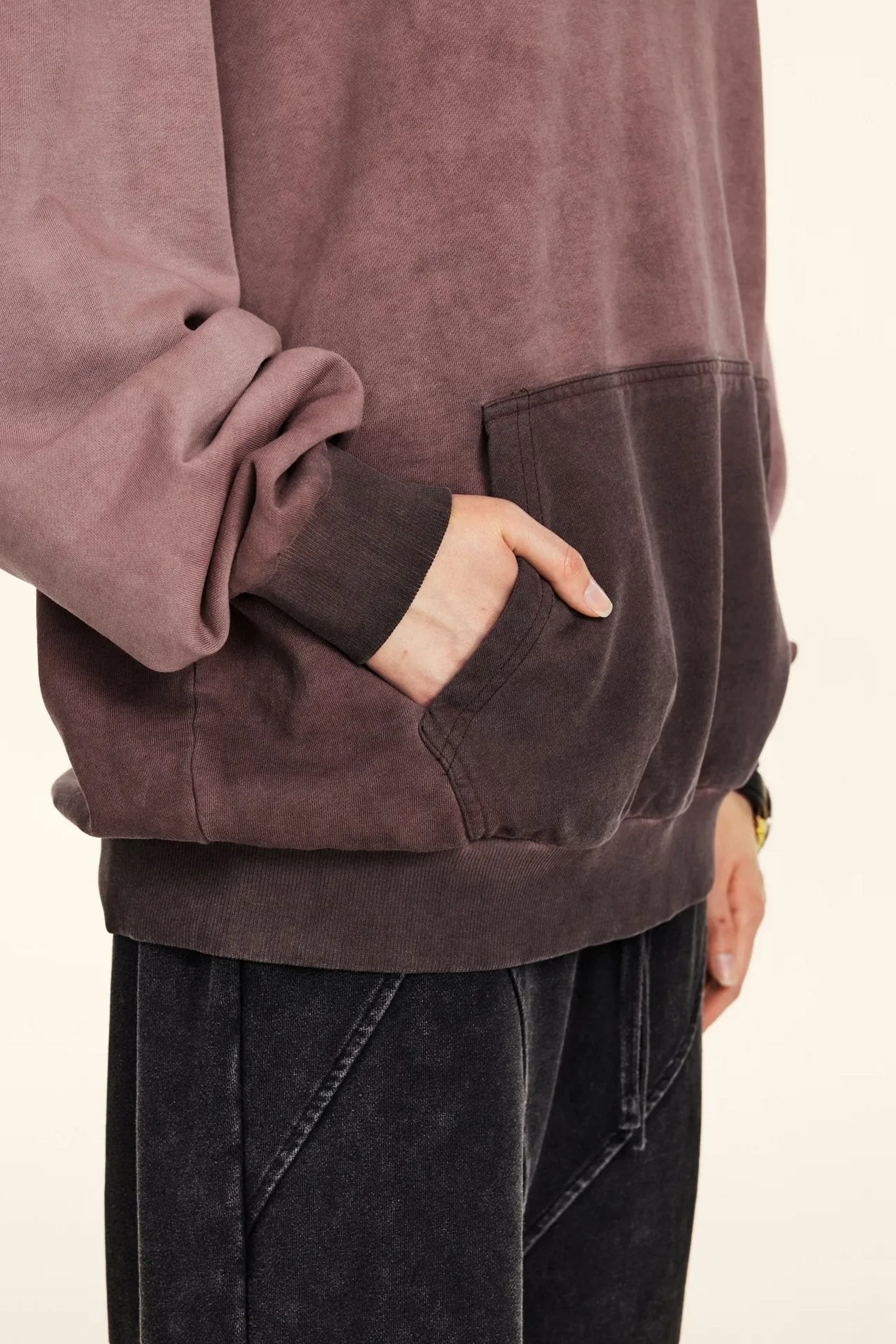 Close-up of a person wearing a brown suede jacket with a neutral background