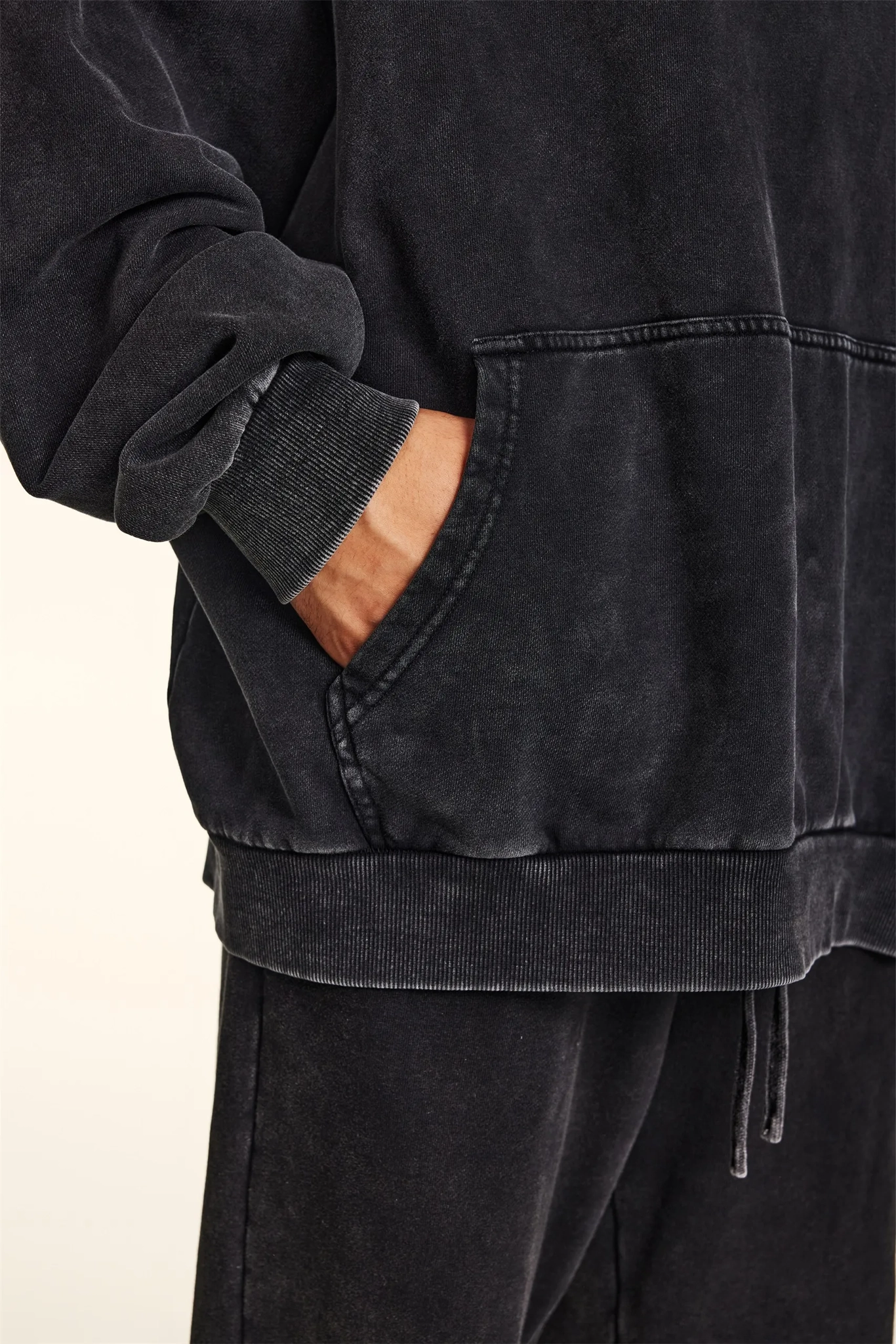 Black hoodie with a pocket on a beige background