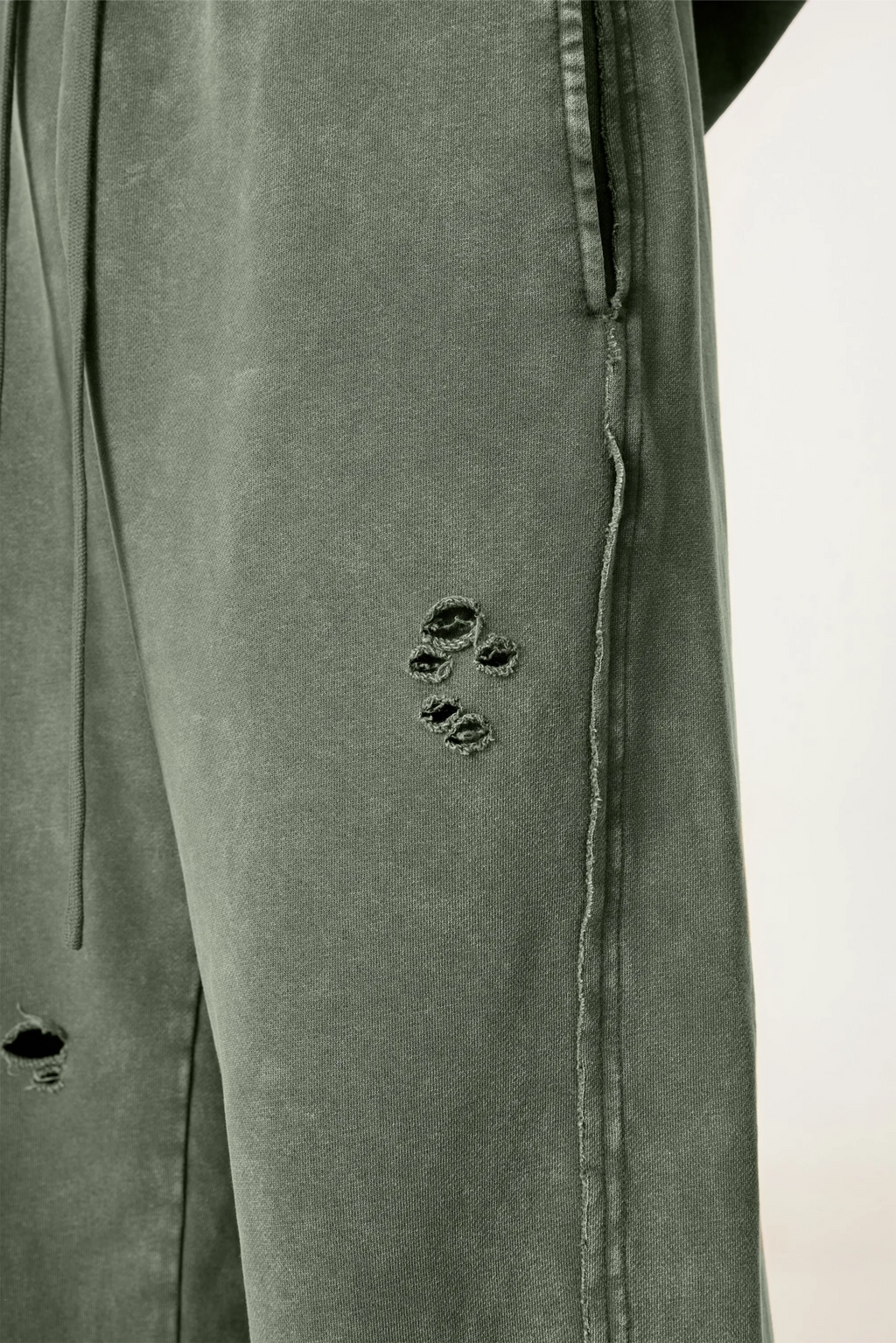 Close-up of a green pants with a paw print design on a white background