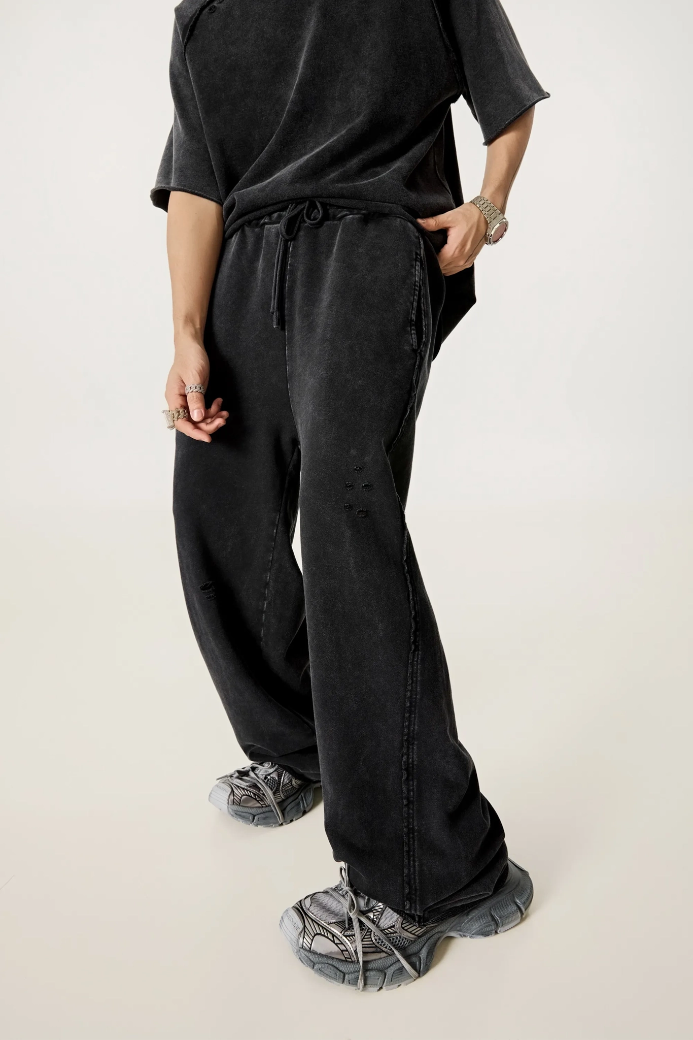 Person wearing black wide-leg pants and a black top on a white background