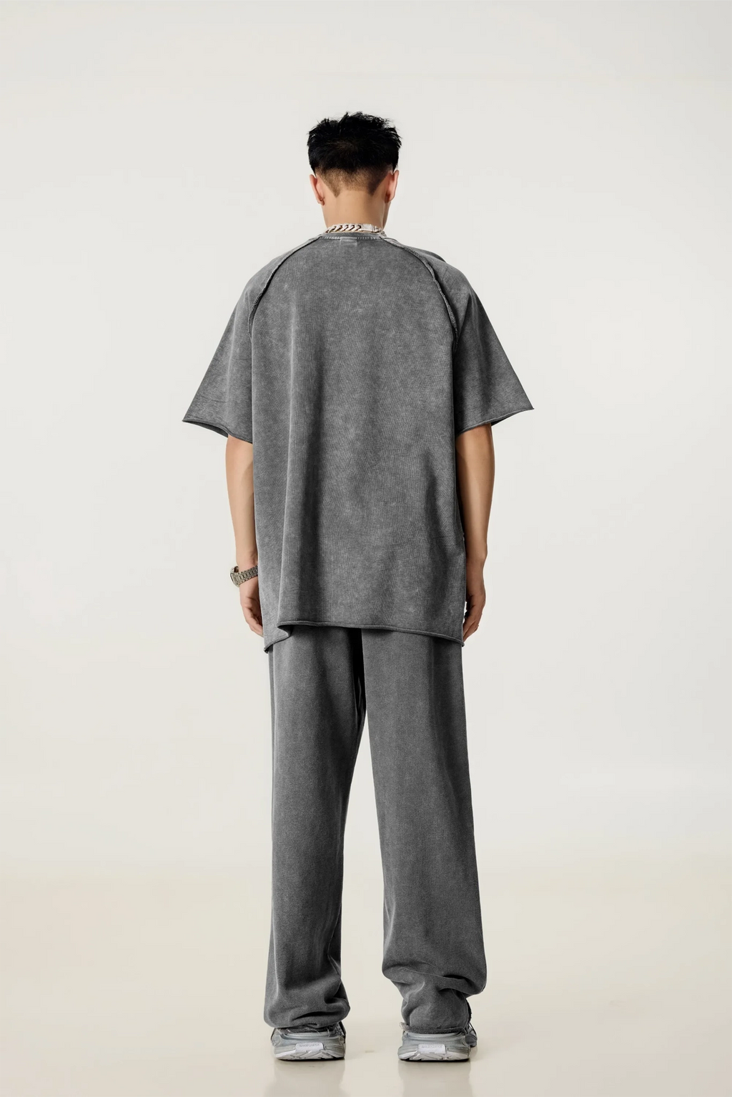 Person wearing a gray outfit on a white background