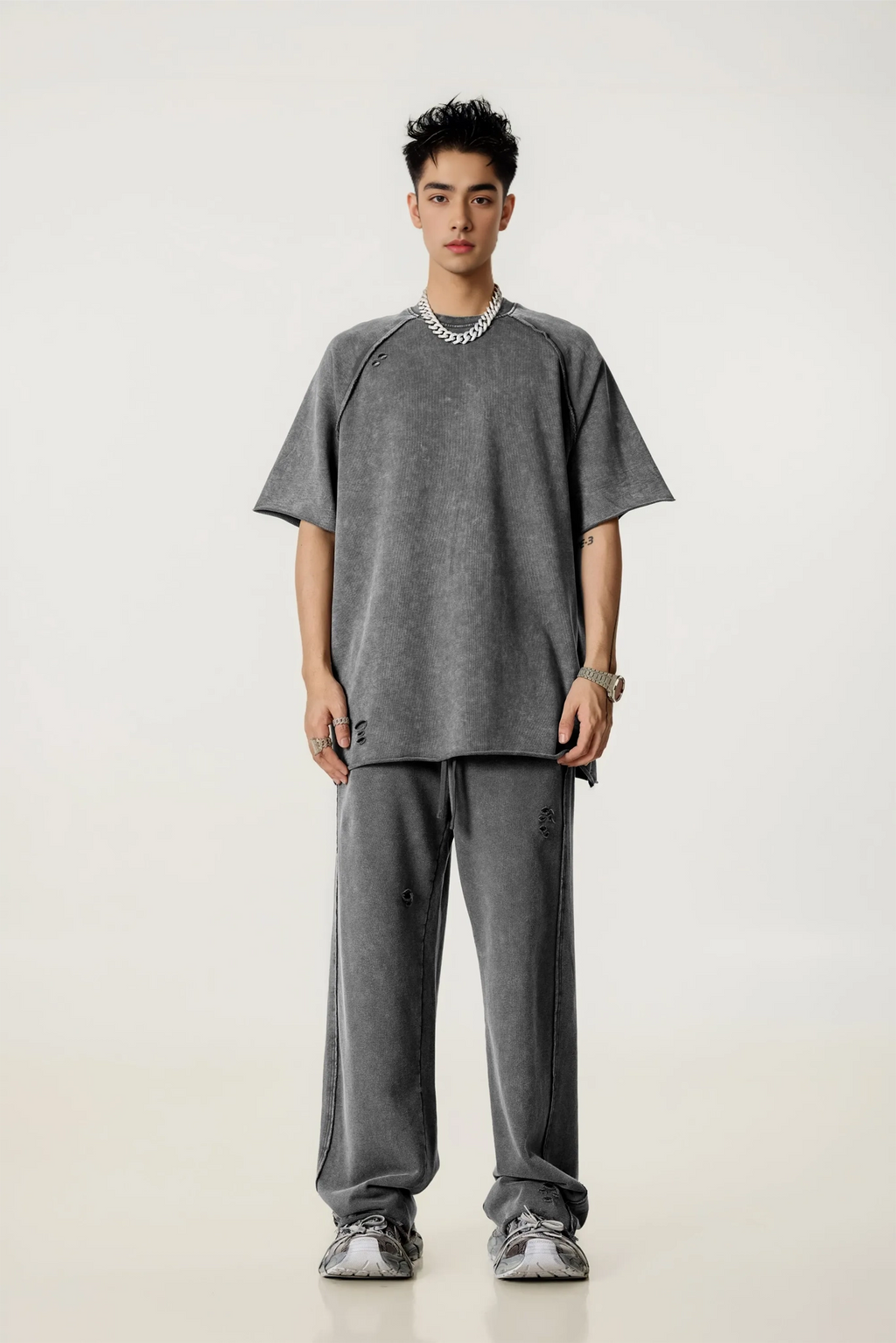 Person wearing a gray outfit on a white background