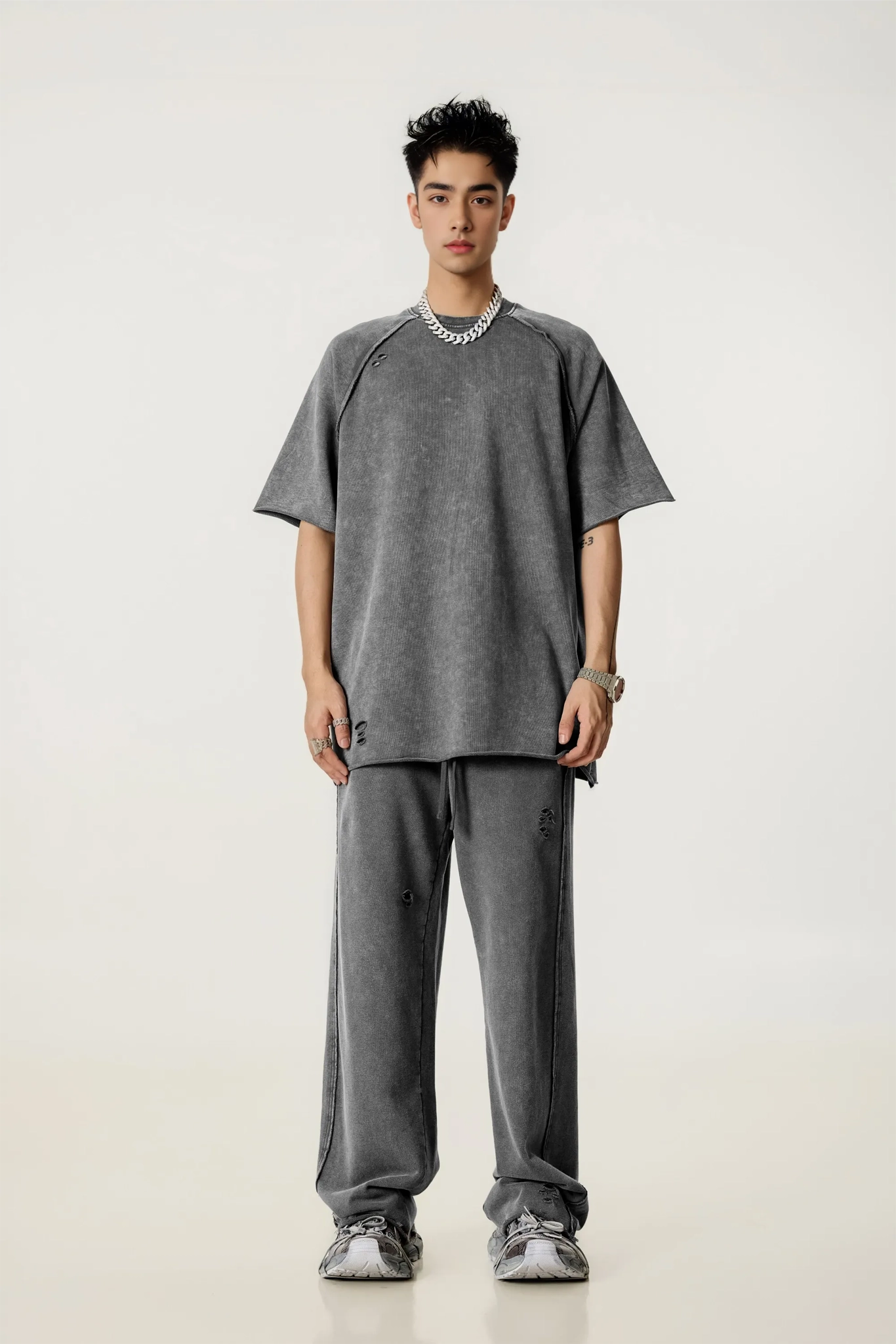 Person wearing a gray outfit on a white background