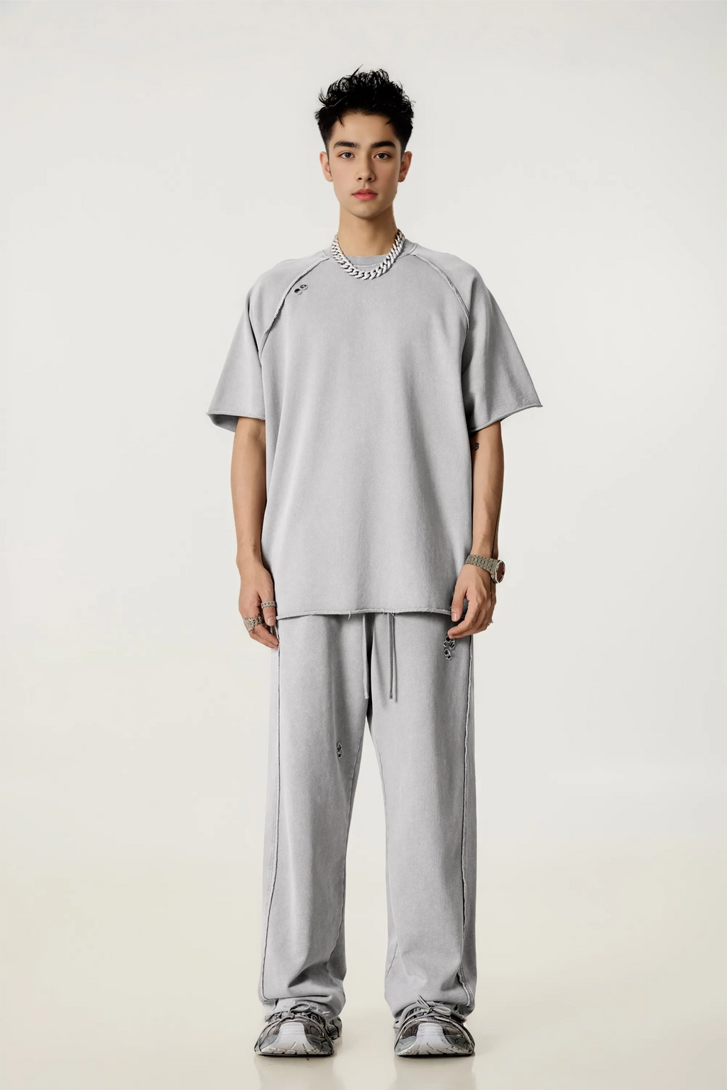 Person wearing a gray outfit on a white background