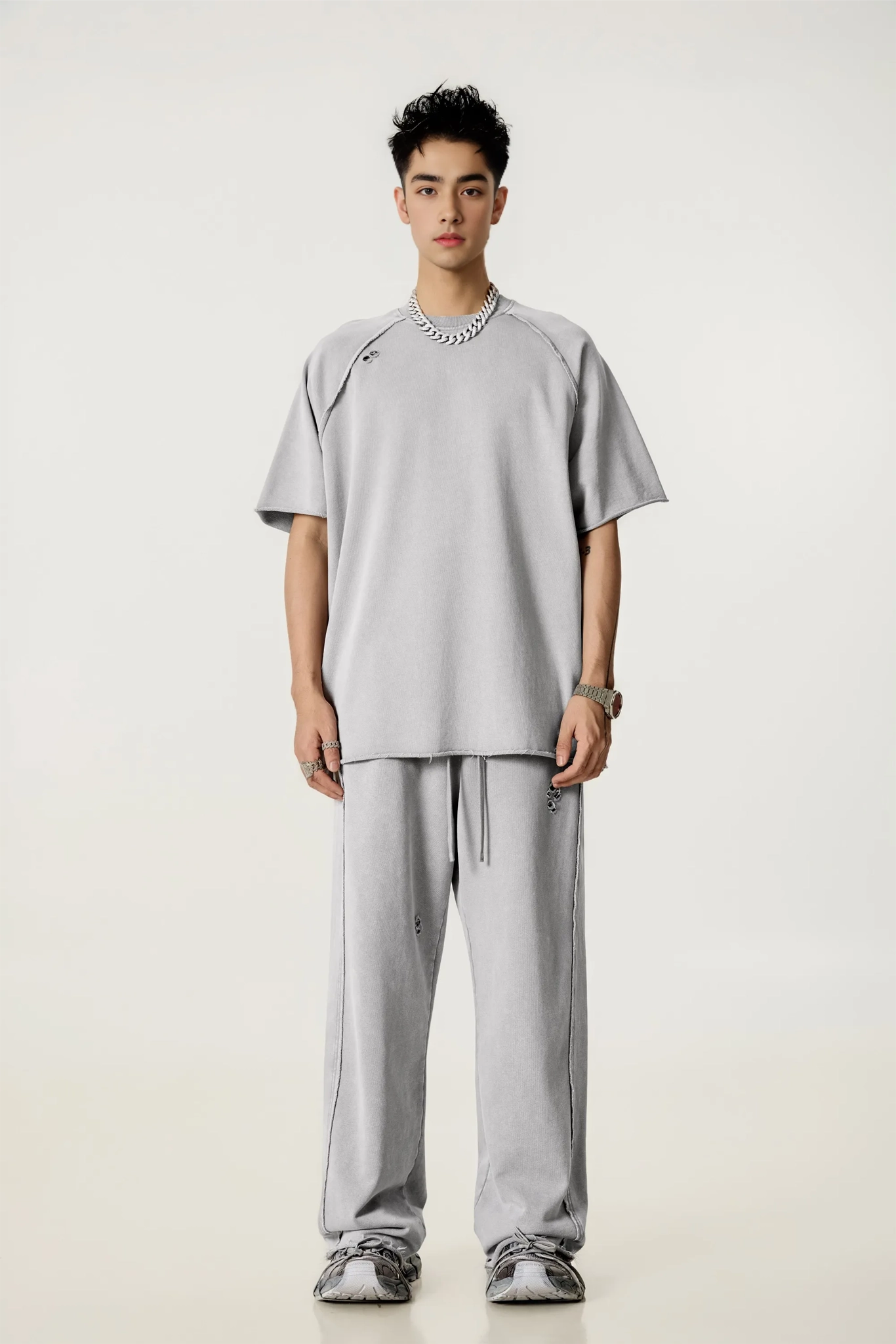 Person wearing a gray outfit on a white background